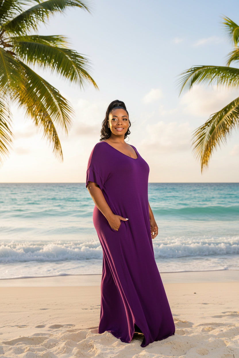 A woman modeling a loose, short-sleeve maxi dress in solid purple against a plain white background.