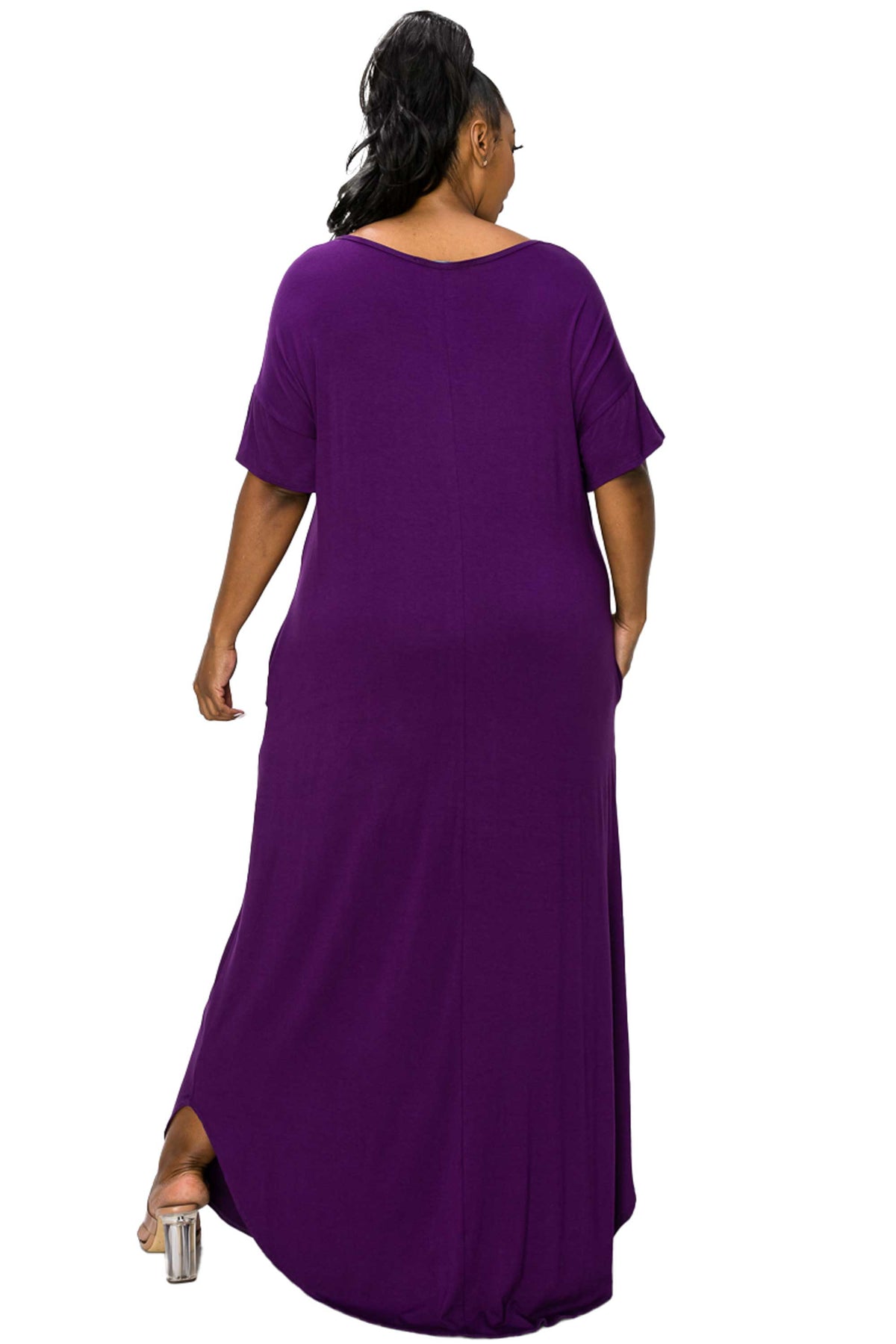 A woman shown from the back wearing a loose, short-sleeve maxi dress in solid purple, photographed against a plain white background.