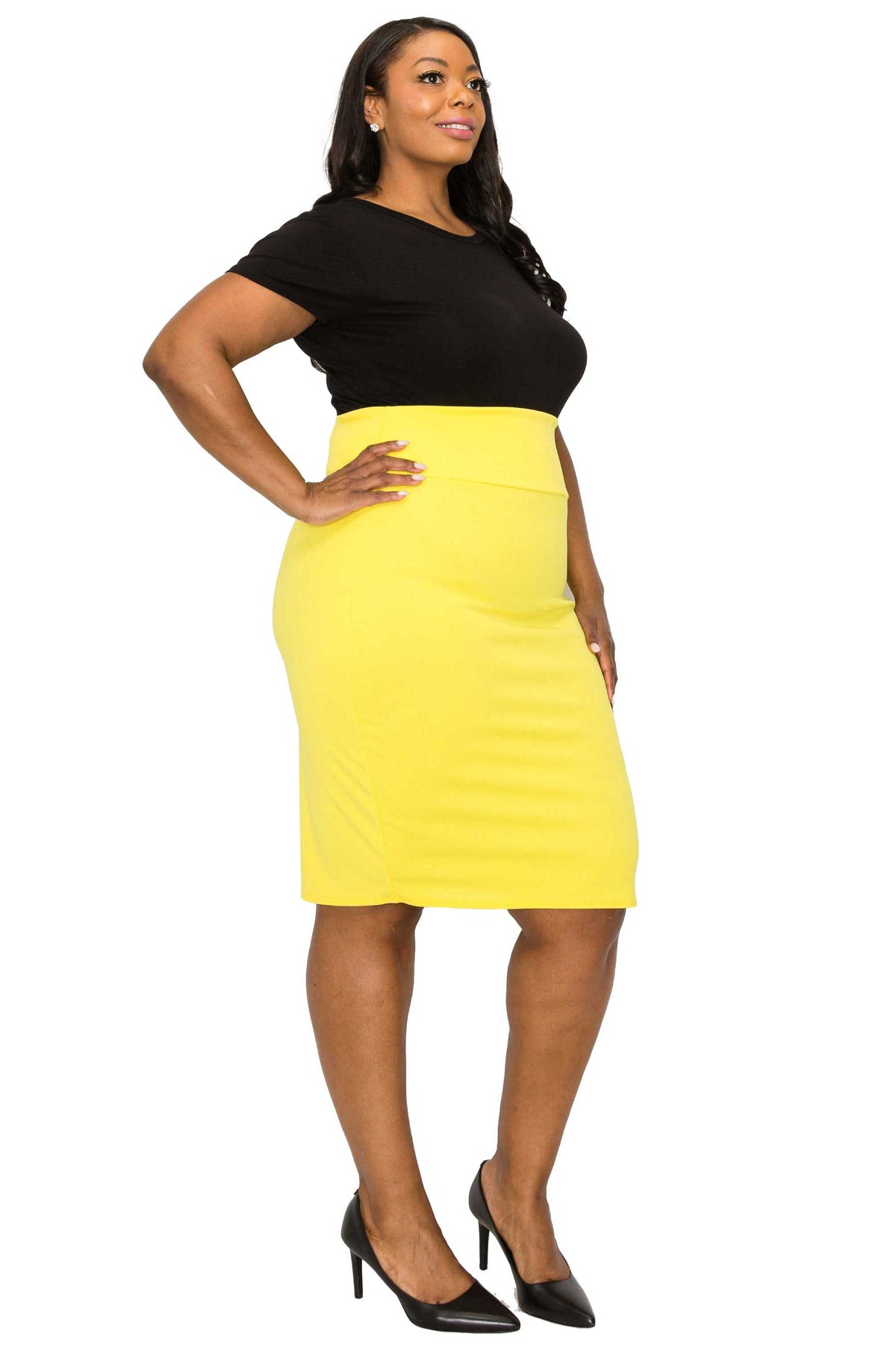 A woman modeling a bright yellow knee-length pencil skirt paired with a black short-sleeve top and black heels, set against a plain white background.