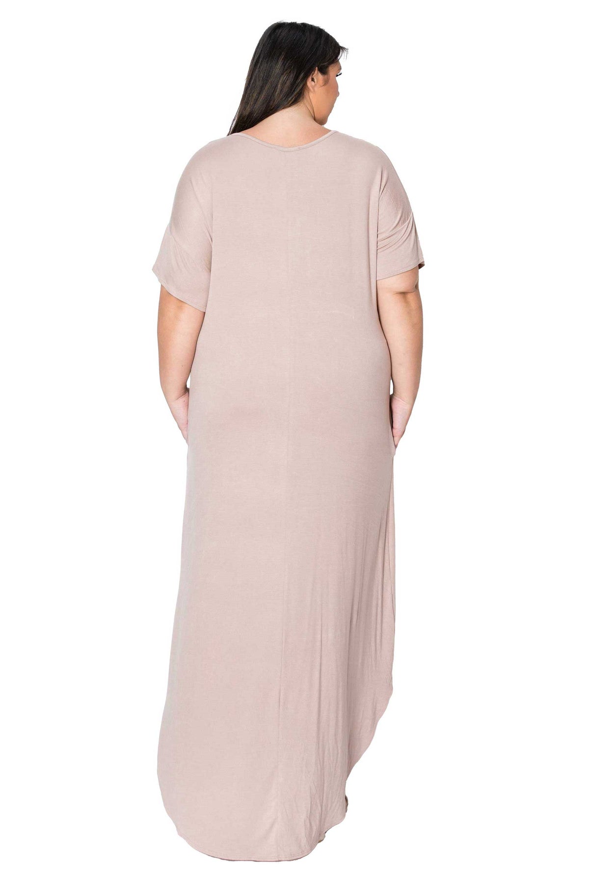 A woman viewed from the back wearing a loose, short-sleeve maxi dress in a soft dusty blush pink color, set against a plain white background.