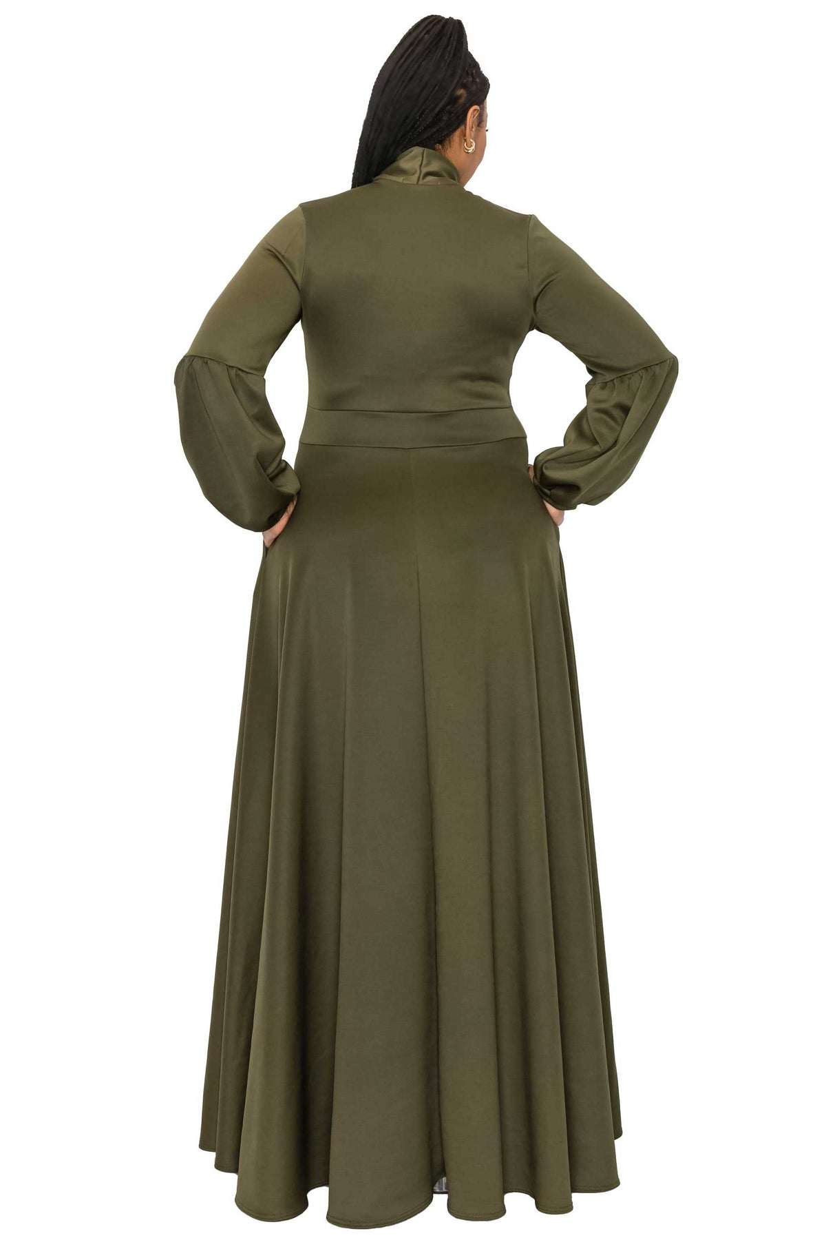 A woman shown from the back wearing a long olive green maxi dress with long sleeves and a high neckline, set against a plain white background.