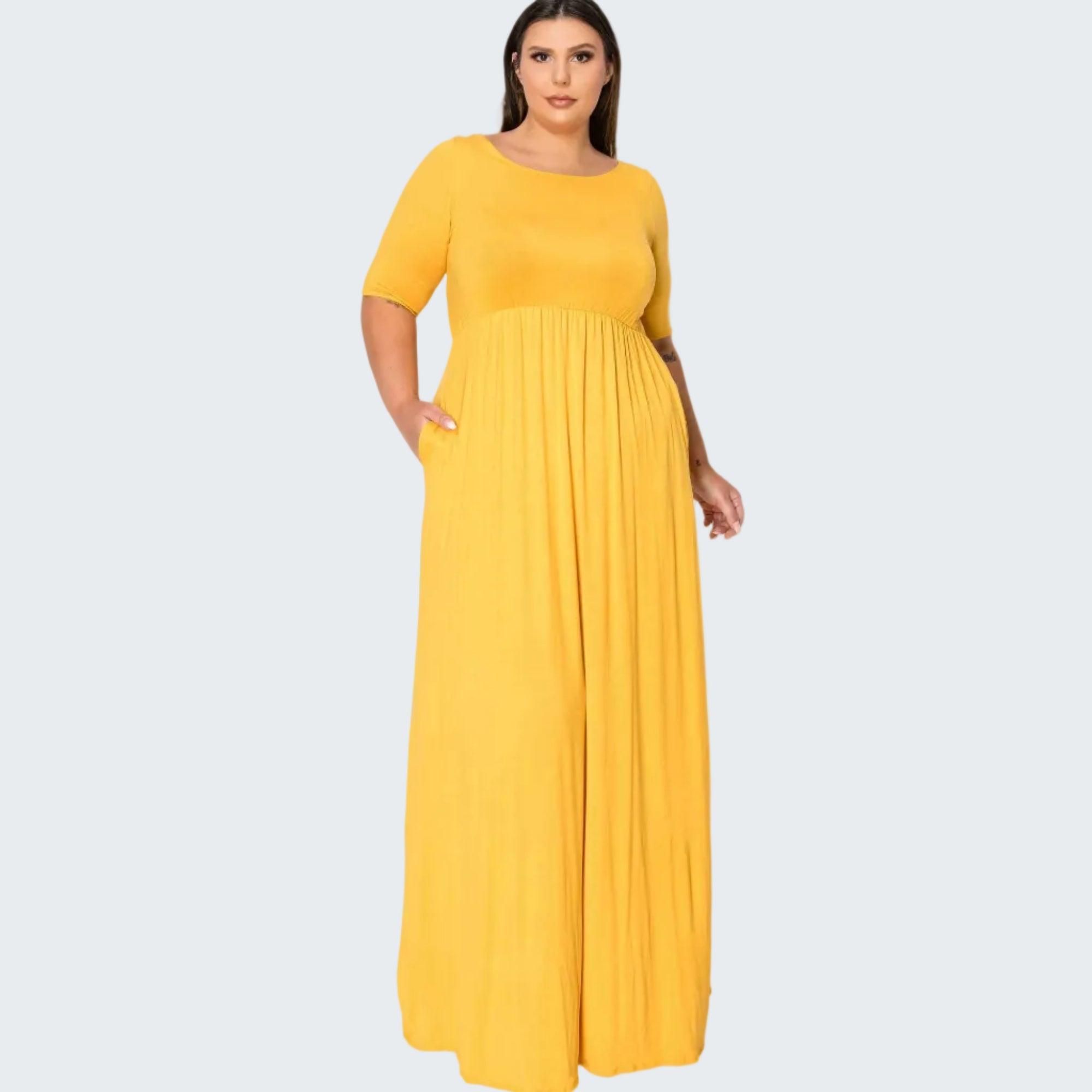 A woman modeling a bright yellow, short-sleeved maxi dress with a pleated skirt against a plain white background.