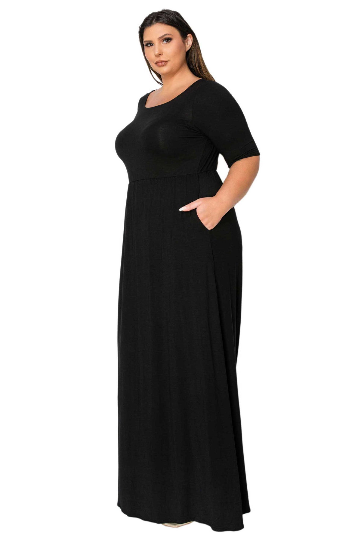A woman modeling a black, short-sleeved maxi dress with side pockets against a plain white background.