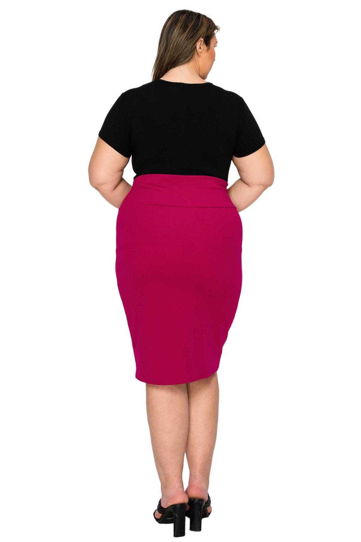 A woman shown from the back wearing a black short-sleeve top and a bright fuchsia pink knee-length pencil skirt, paired with black high-heeled sandals, against a plain white background.