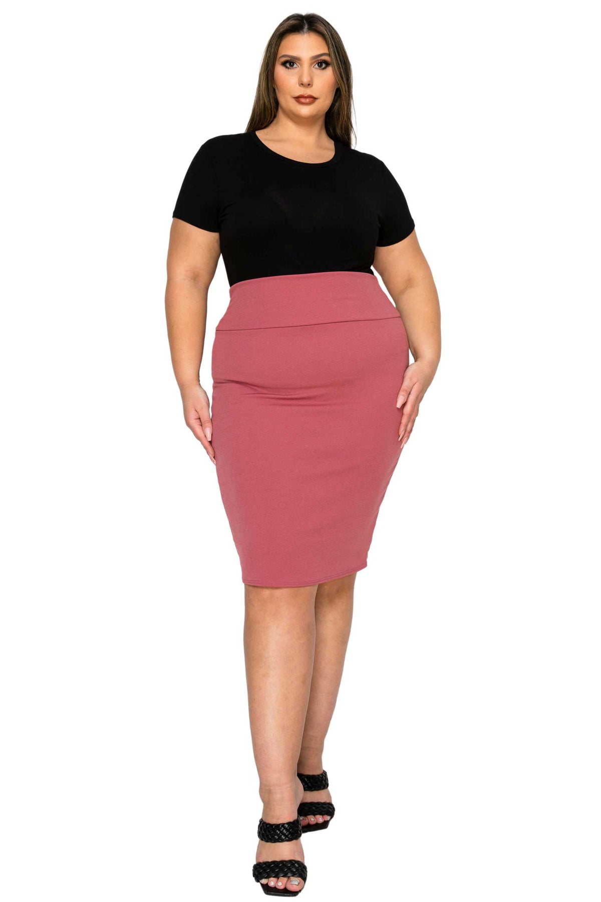A woman modeling a two-tone bodycon dress with a black short-sleeve top and a dusty rose pink knee-length skirt, paired with black strappy heels, against a plain white background.