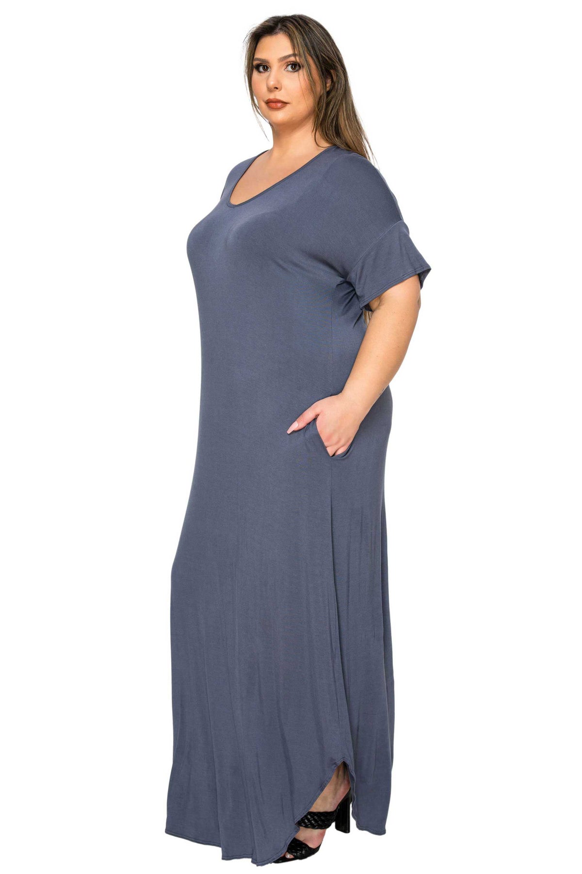 A woman modeling a loose-fitting, slate blue maxi dress with short sleeves and a V-neckline, shown against a plain white background.