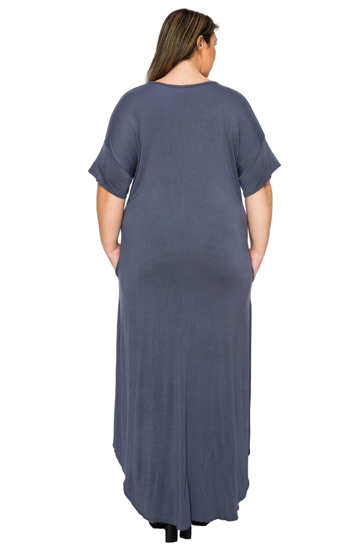 A woman viewed from the back wearing a loose, short-sleeve maxi dress in a muted slate blue-gray color, set against a plain white background.
