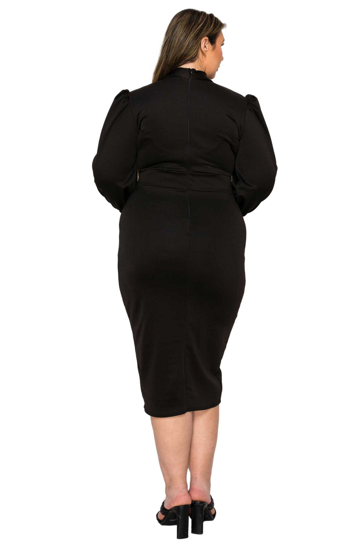 A woman viewed from the back wearing a fitted black midi dress with puffed long sleeves and black high-heeled sandals against a plain white studio background.