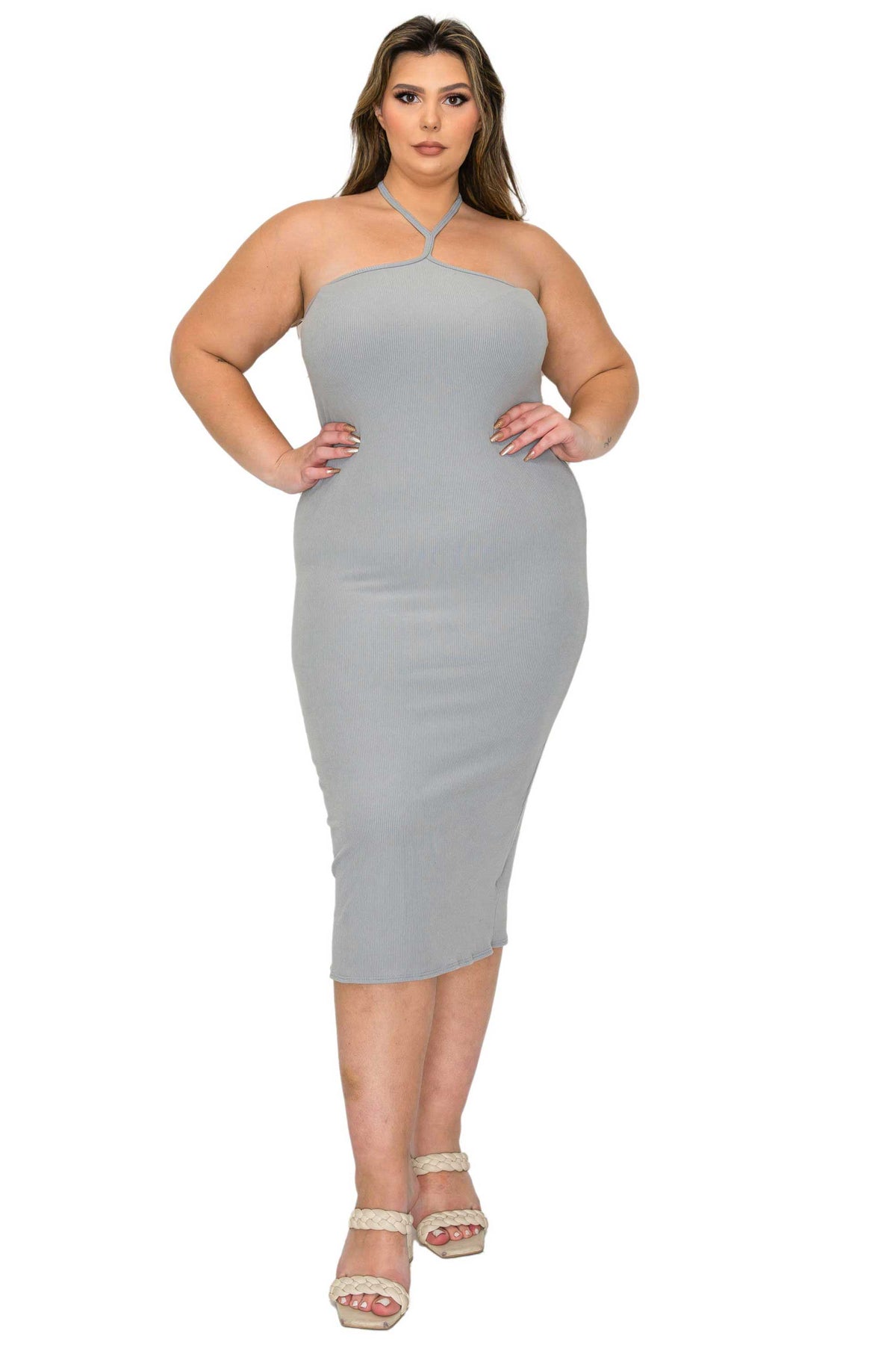 A woman modeling a light gray halter-neck bodycon midi dress with matching gray tie straps at the neckline, paired with beige platform sandals, against a plain white background.