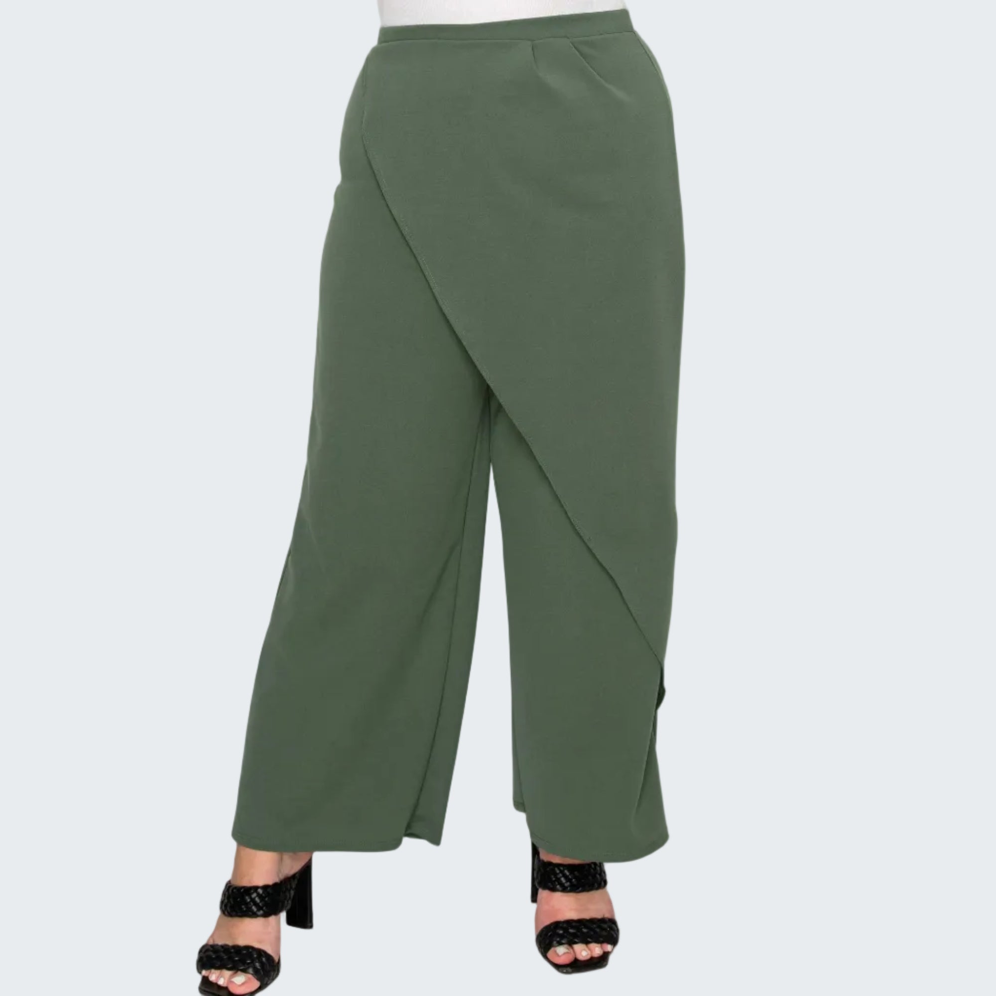 A pair of olive green wide-leg cropped pants with an asymmetrical wrap-style front, shown on a model wearing black heeled sandals against a white background.