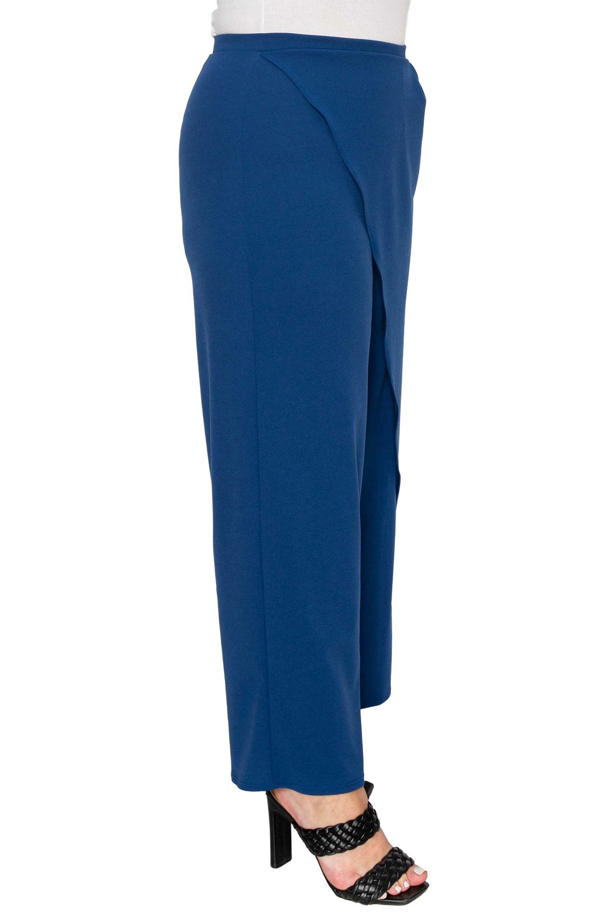 A pair of royal blue wrap-style cropped pants shown on a model from the side, paired with black heeled sandals against a plain white background.