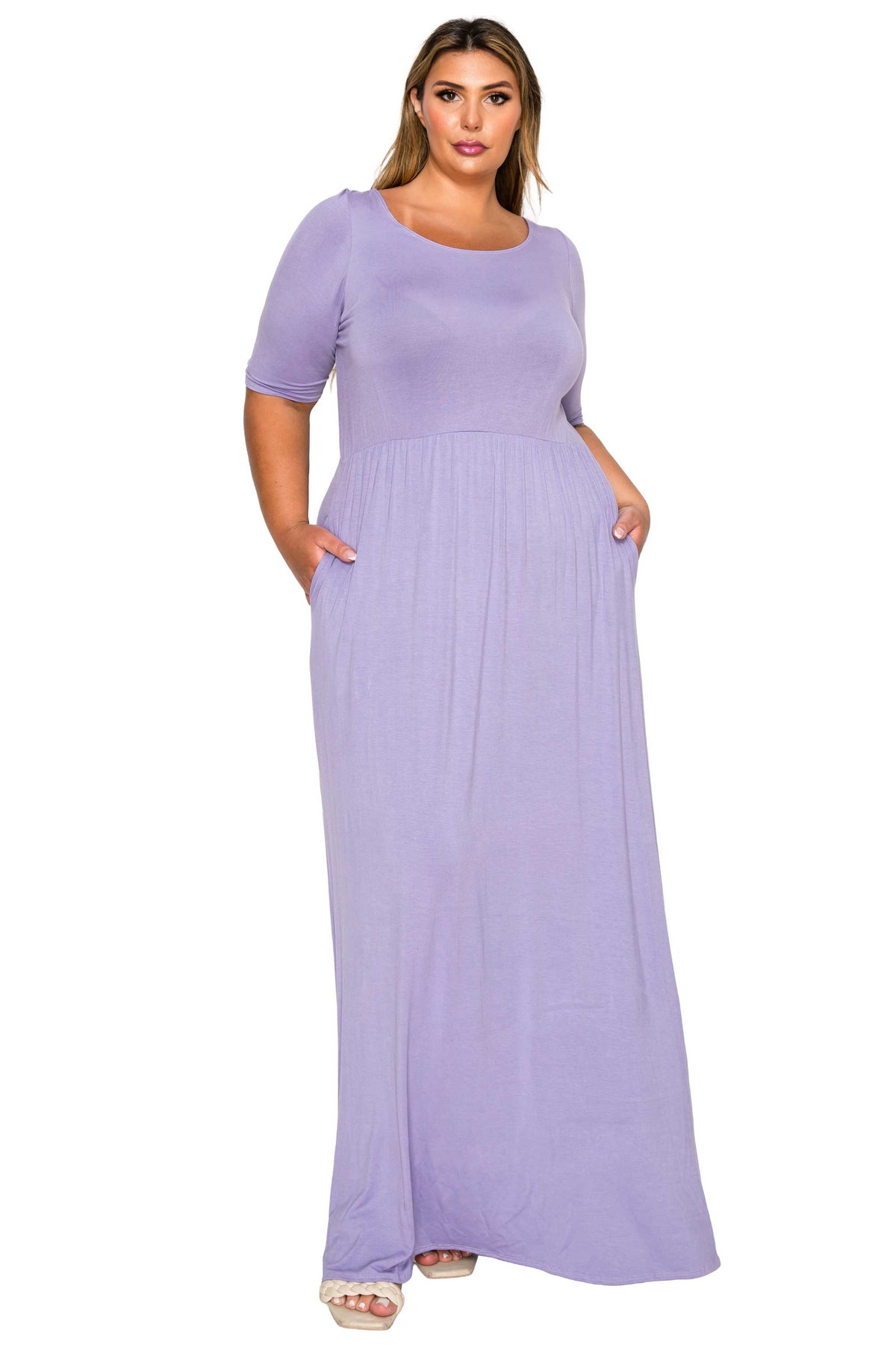 A woman modeling a lavender purple short-sleeve maxi dress with side pockets, shown against a plain white background.