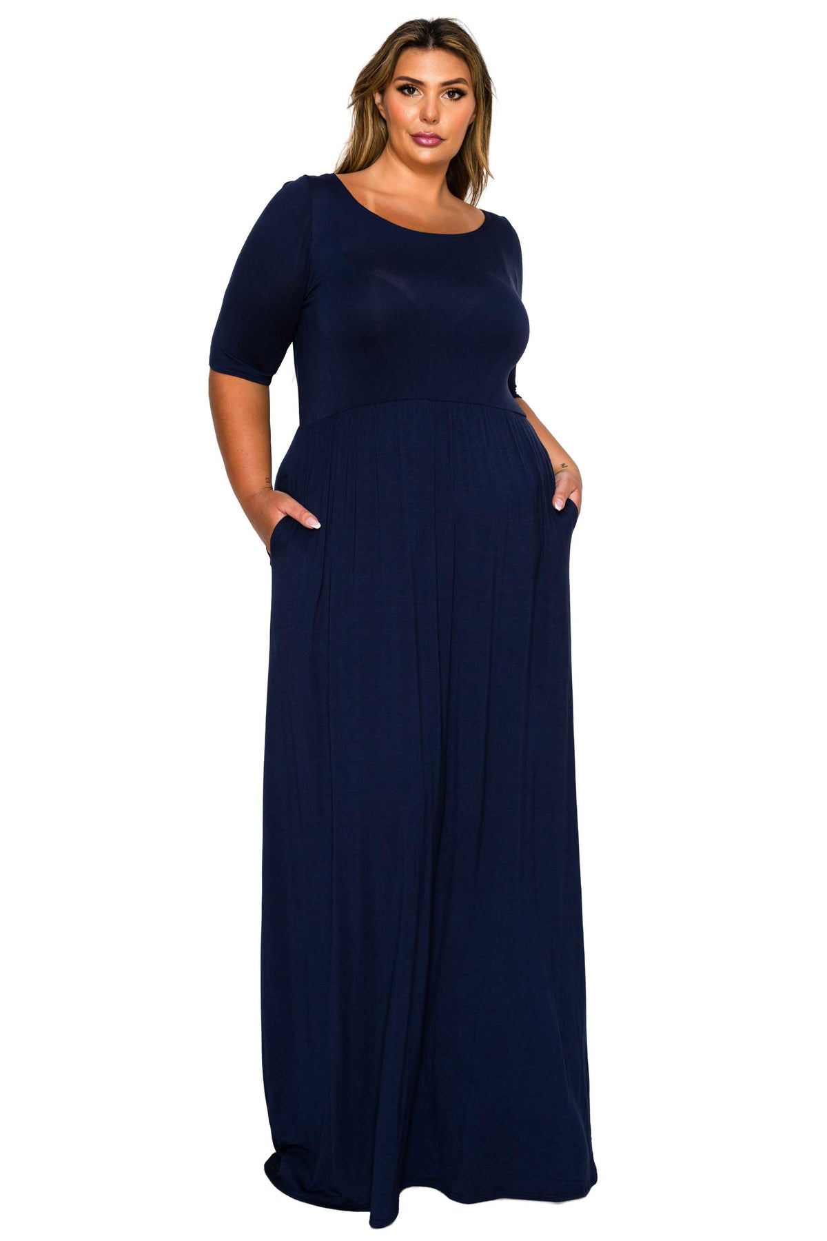 A woman modeling a navy blue maxi dress with short sleeves, a round neckline, and side pockets against a plain white background.
