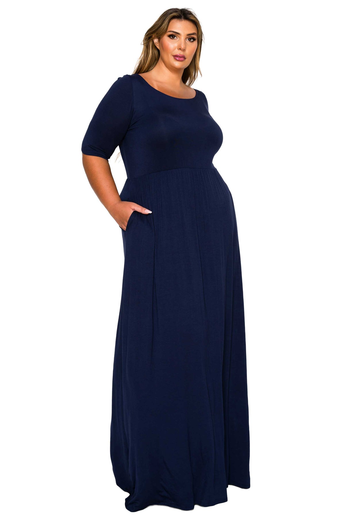 A woman modeling a navy blue short-sleeve maxi dress with a scoop neckline and side pockets, set against a plain white background.
