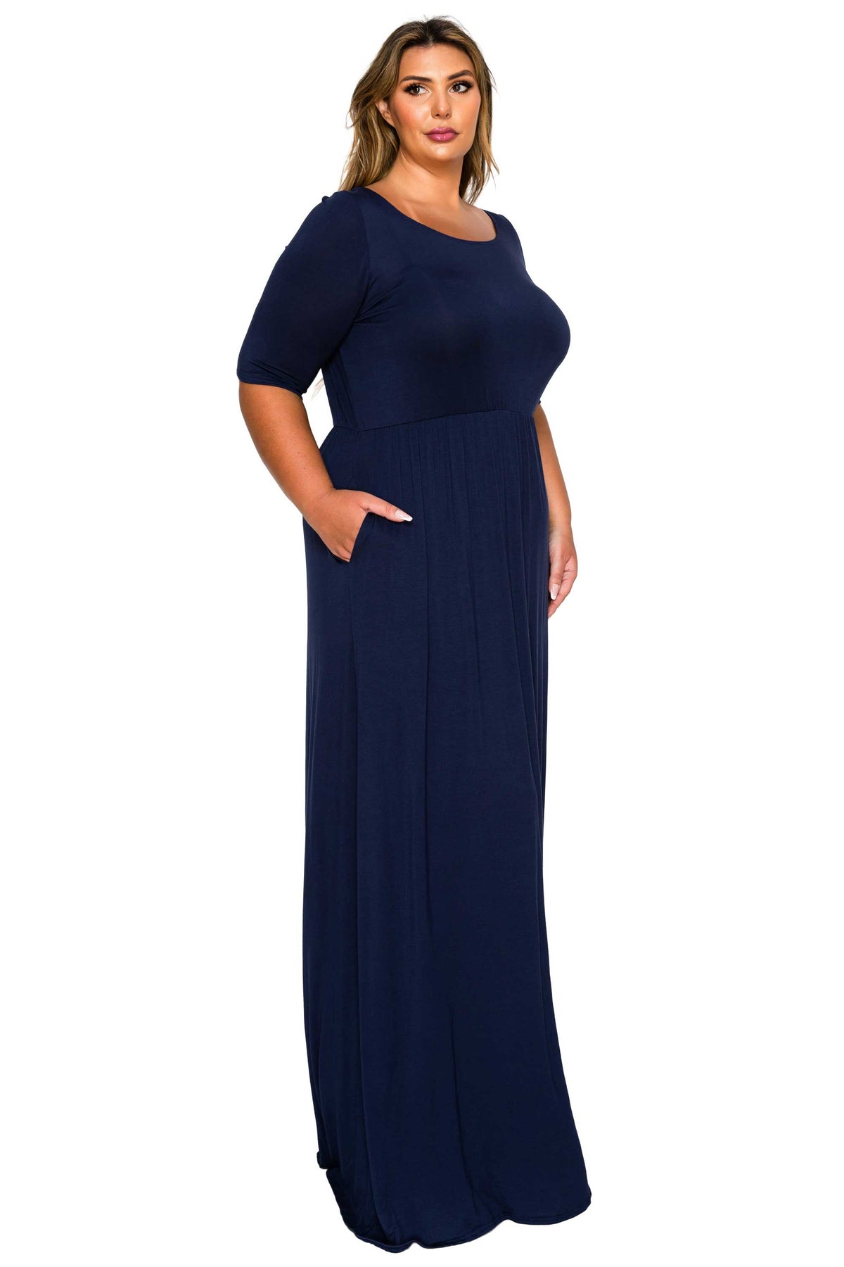 A woman modeling a navy blue maxi dress with short sleeves, a round neckline, and side pockets against a plain white background.