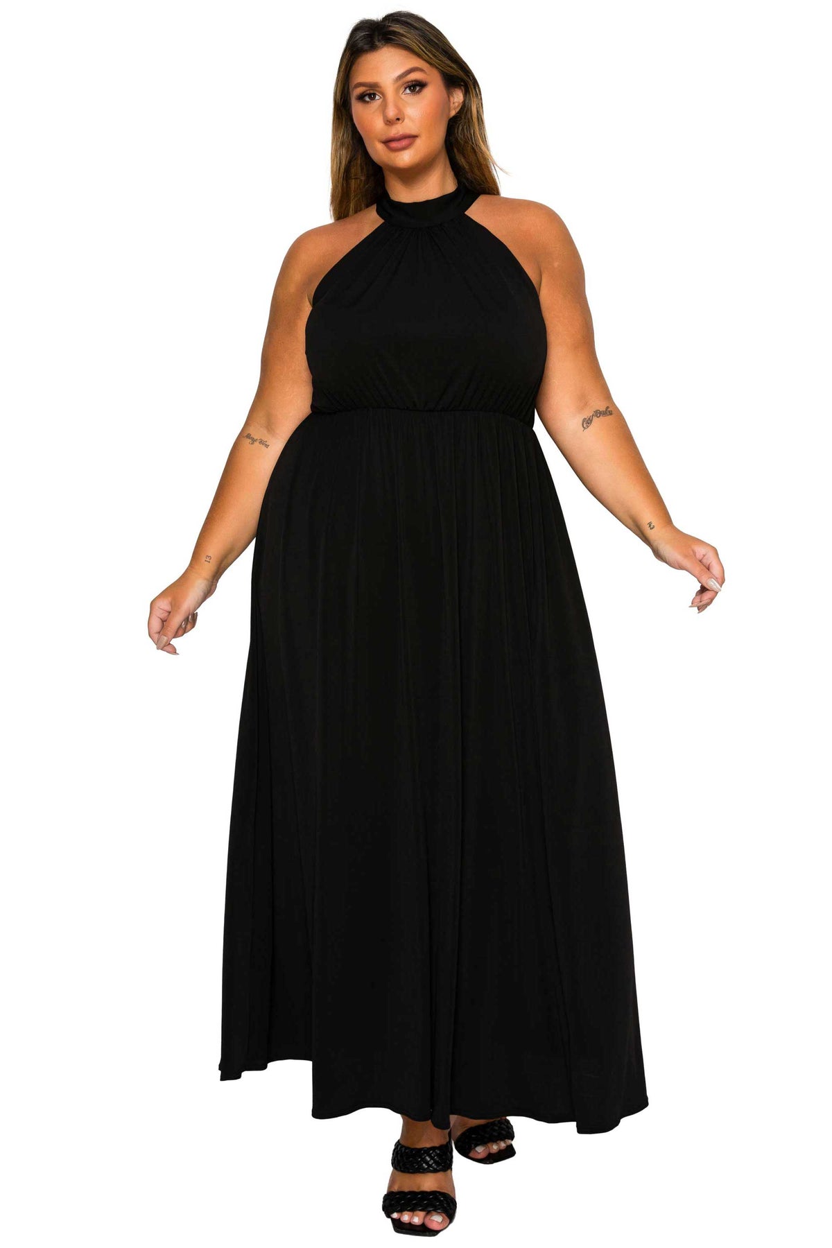 A woman modeling a sleeveless black halter-neck maxi dress with a gathered waist and flowing skirt, shown against a plain white background.
