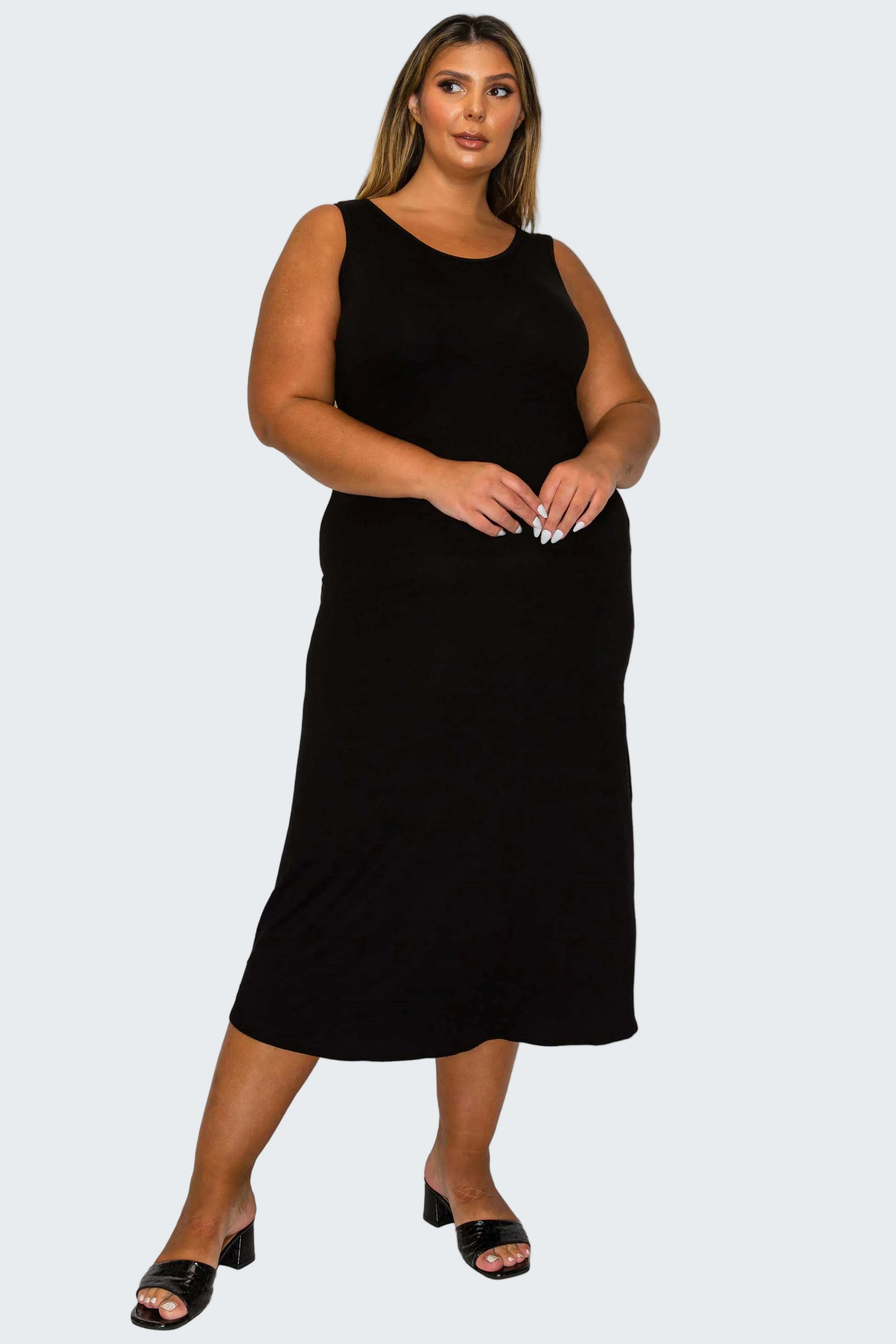 A woman modeling a sleeveless black midi dress against a plain white background.