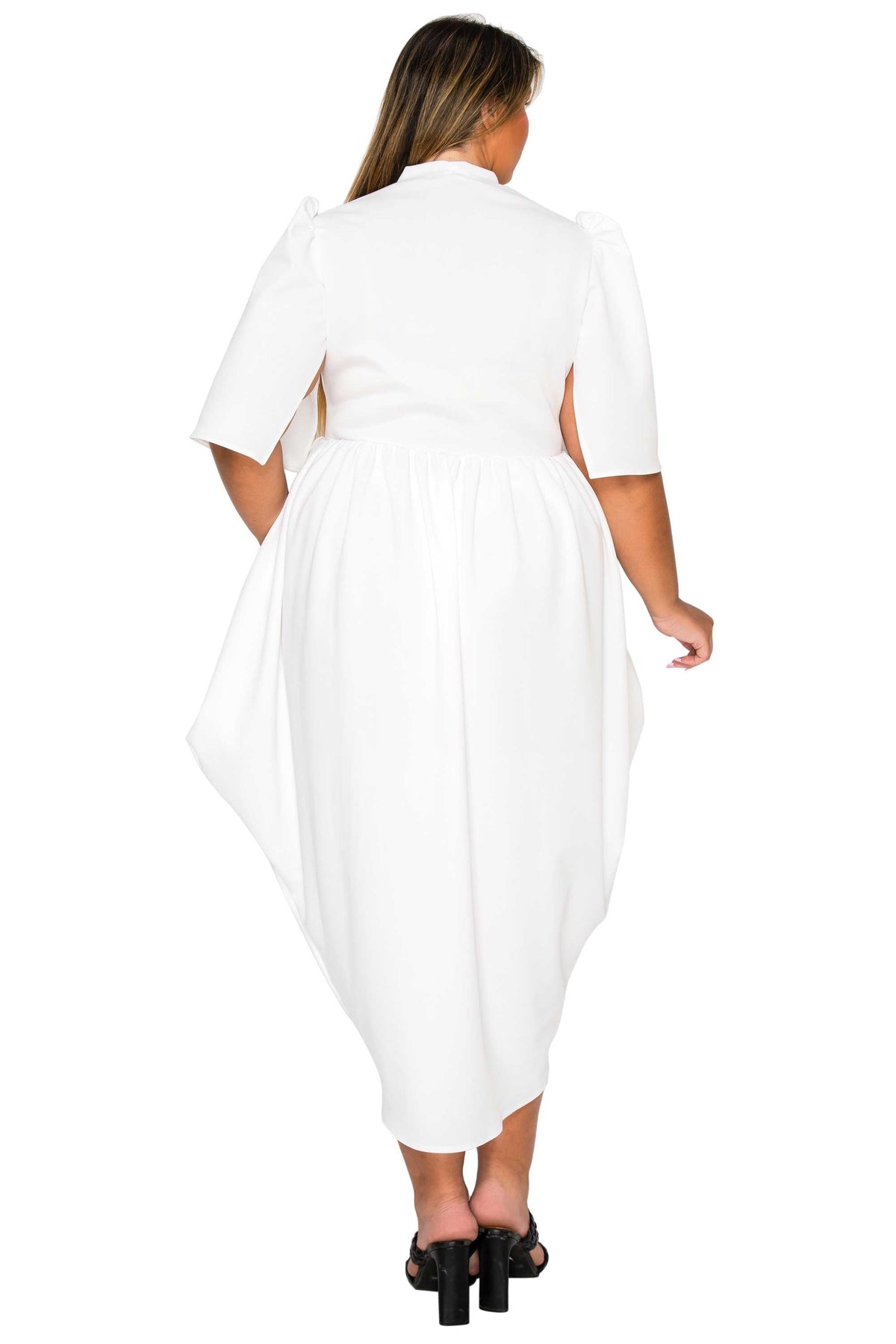 A woman viewed from behind wearing a white midi dress with short puff sleeves, a high collar, and a gathered waist, paired with black heeled sandals against a plain white background.