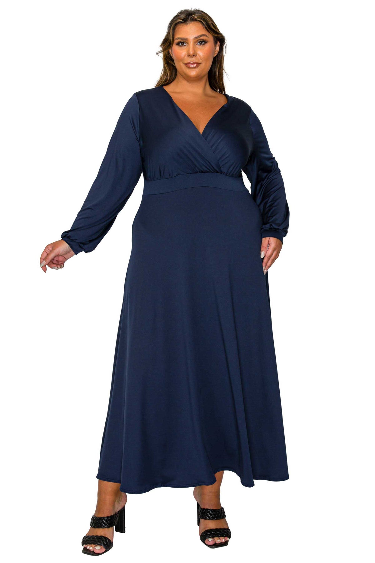 A woman modeling a navy blue long-sleeve maxi dress with a V-neckline and wrap-style bodice, shown against a plain white background.