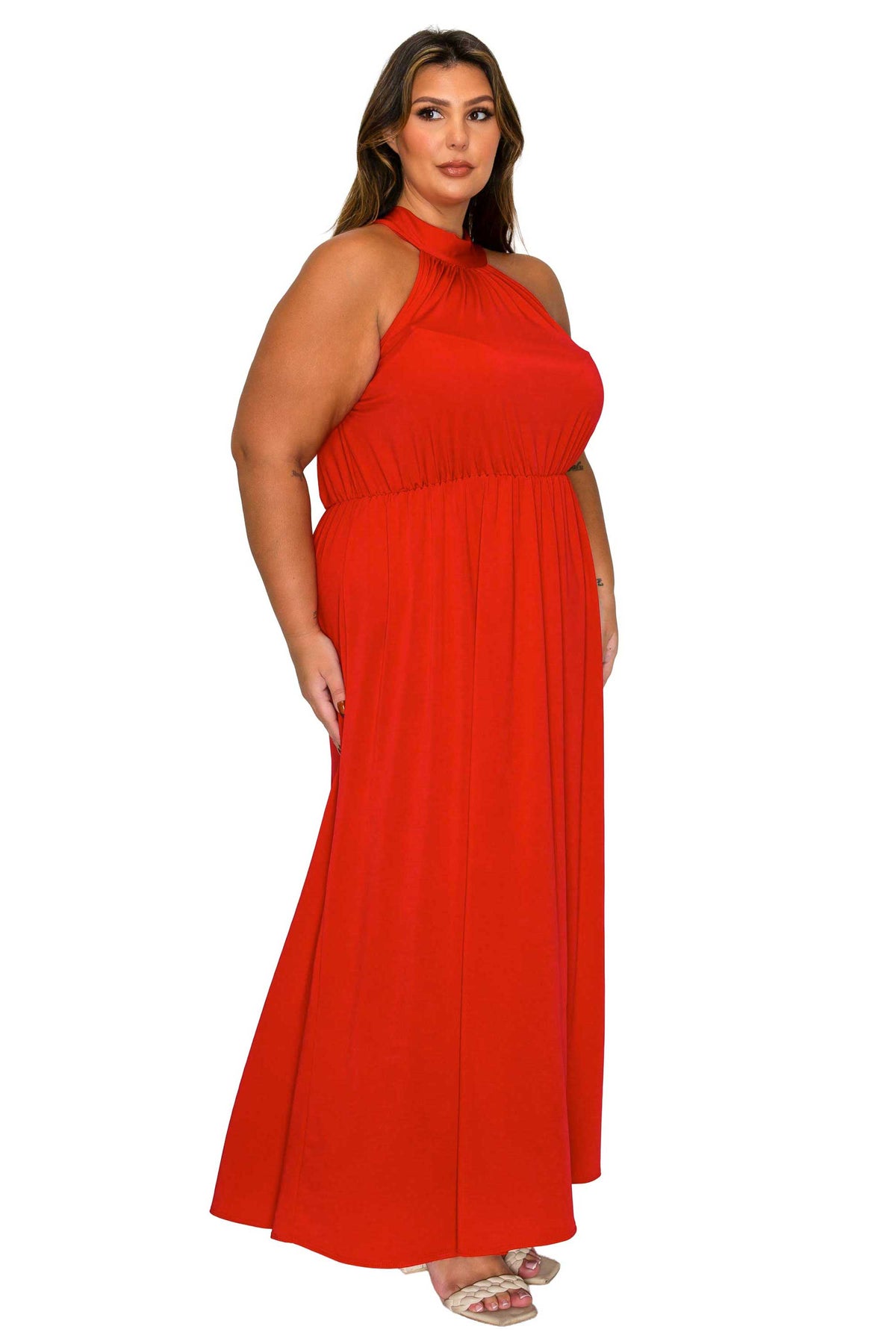 A woman modeling a bright red halter-neck maxi dress with a gathered waist and flowing skirt, shown against a plain white background.
