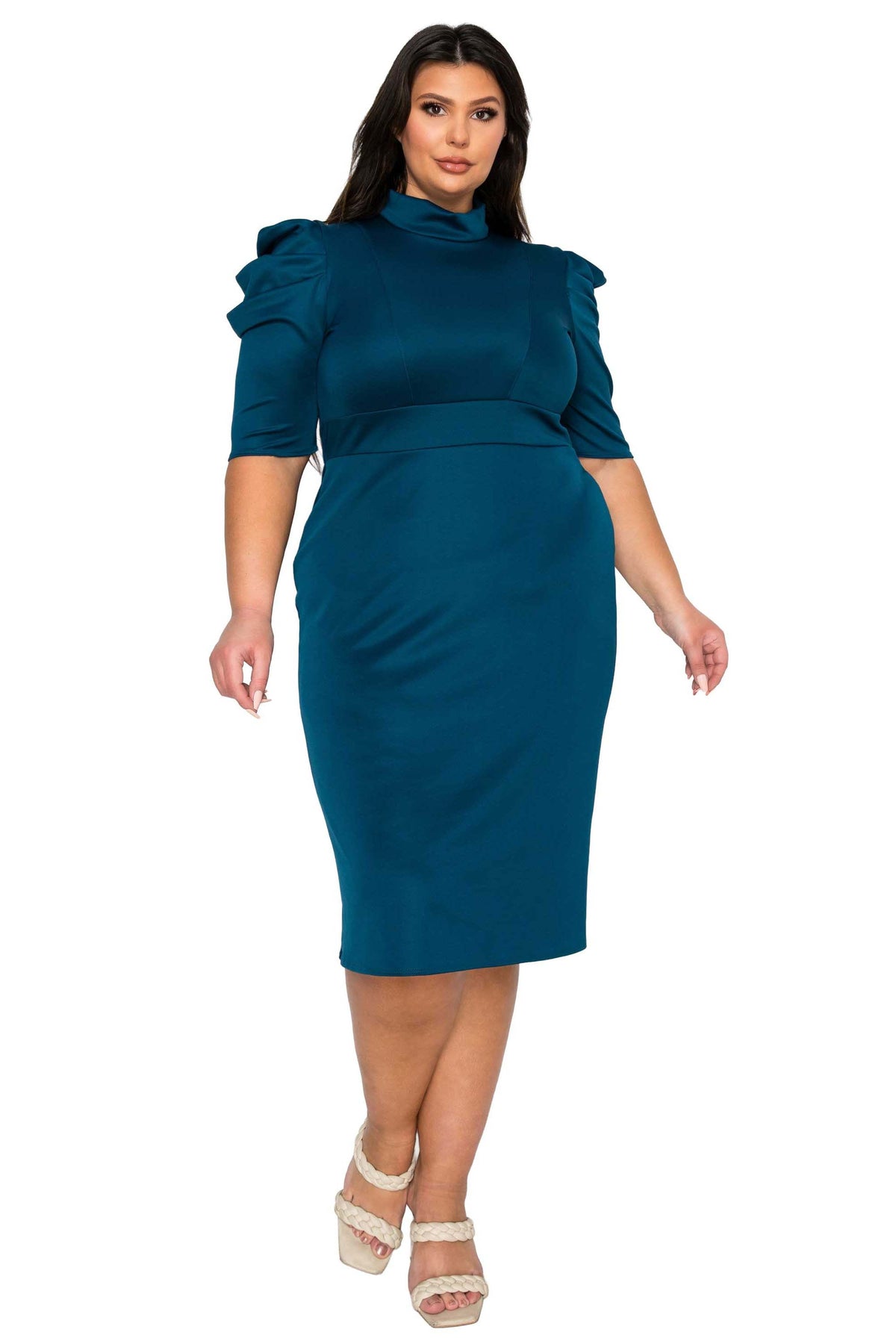 A woman modeling a teal blue mock-neck midi dress with puffed elbow-length sleeves and a defined waist, paired with beige platform sandals, against a plain white background.