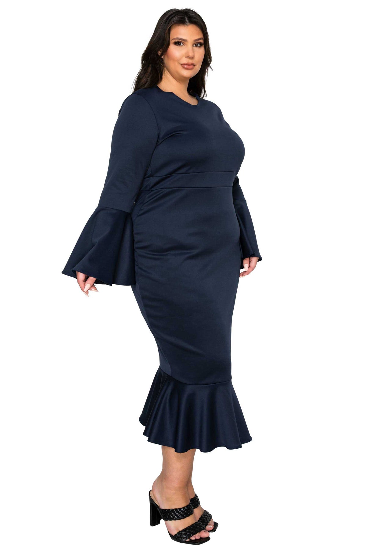 Woman wearing a navy blue dress with bell sleeves on a white background