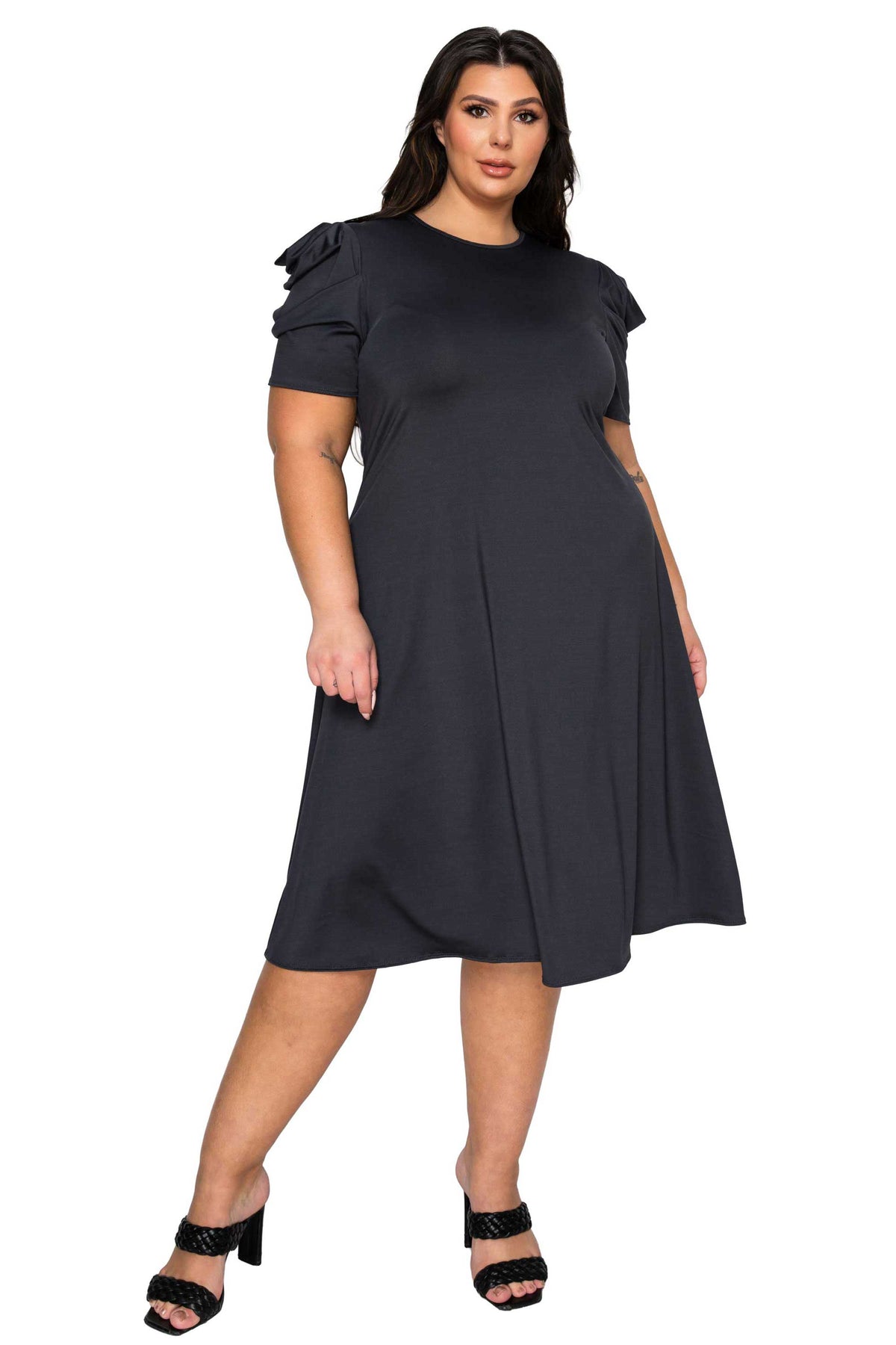 Woman wearing a black dress with ruffled sleeves on a white background
