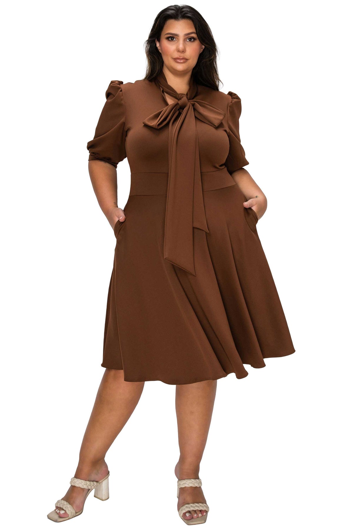 Woman wearing a brown dress with a bow tie on a white background