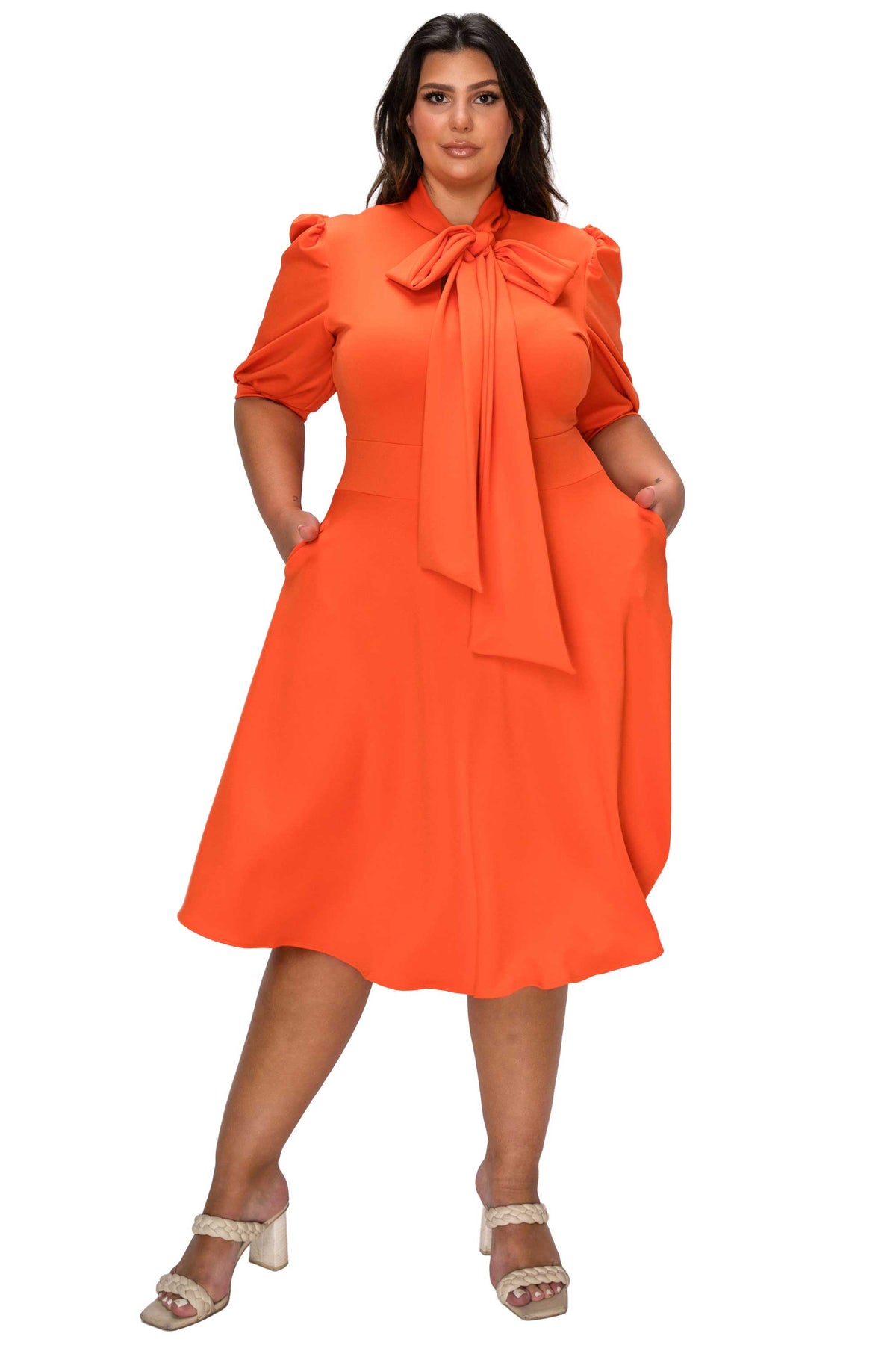 Woman wearing an orange dress with a bow tie on a white background