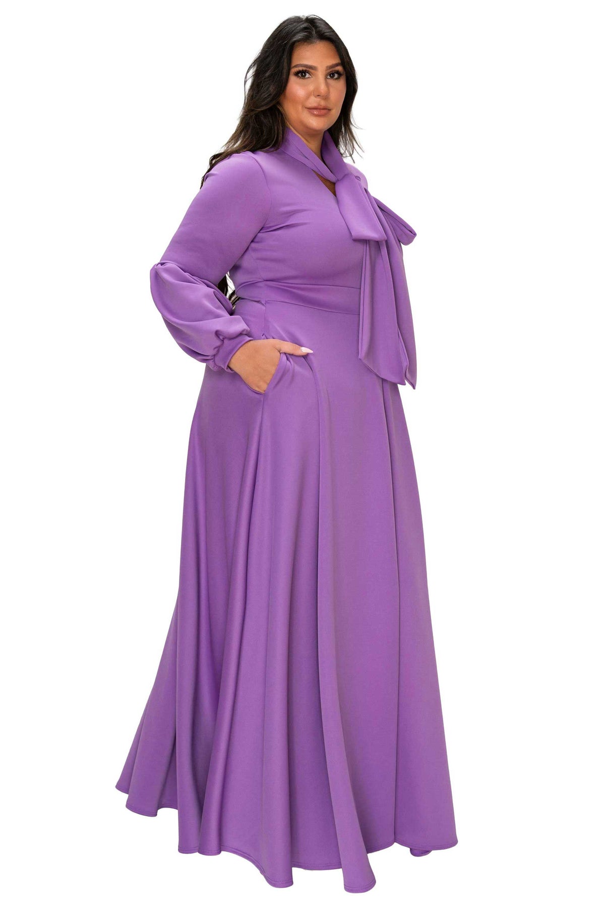 Woman wearing a long purple dress with a belt on a white background