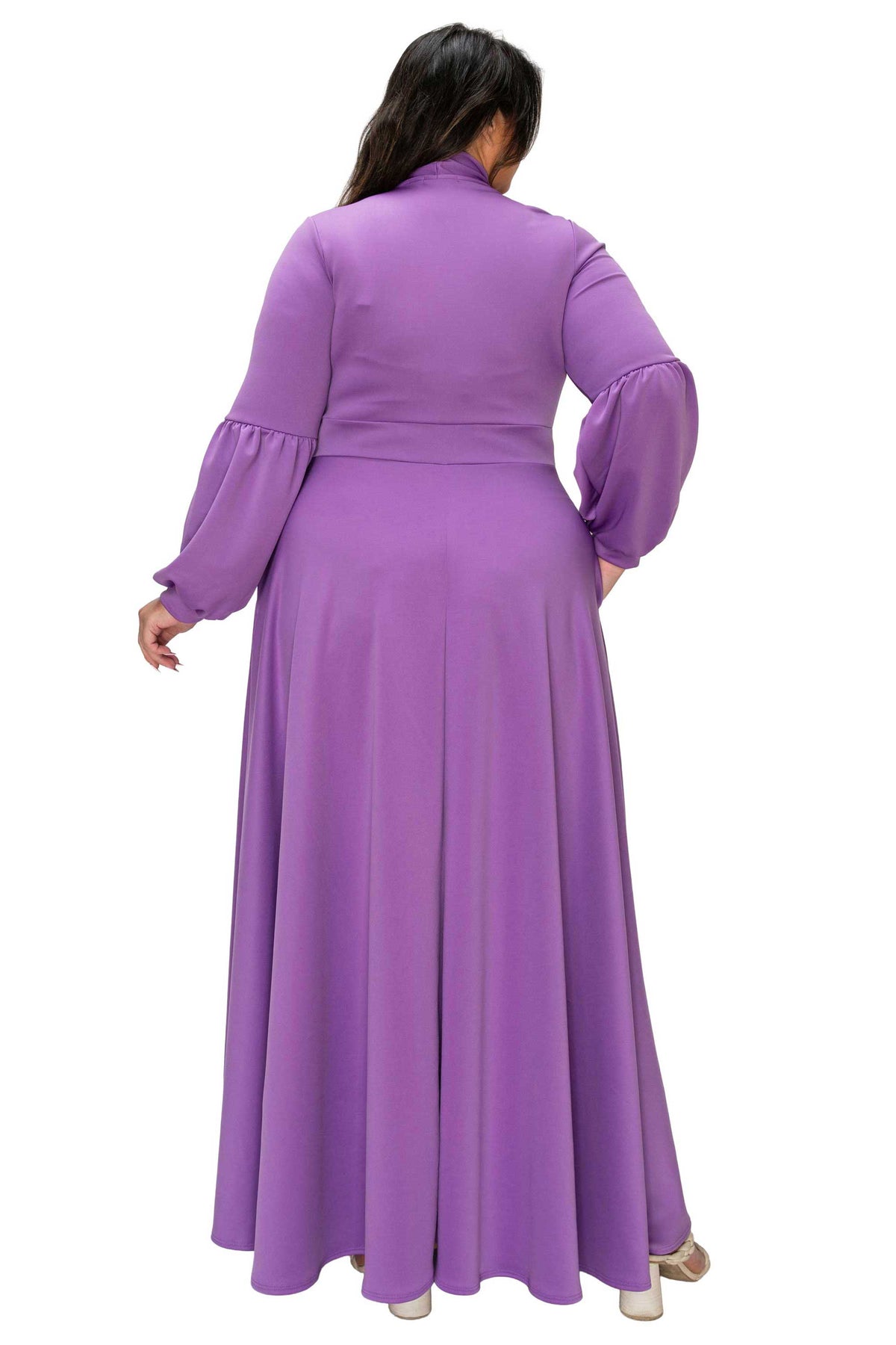 Woman wearing a long purple dress with a matching jacket on a white background
