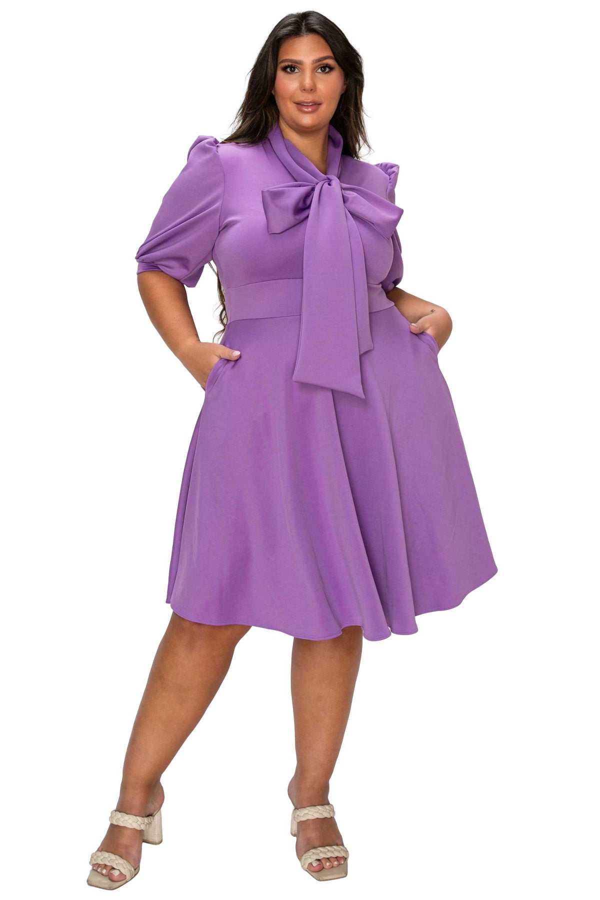 Woman wearing a purple dress with a bow tie on a white background
