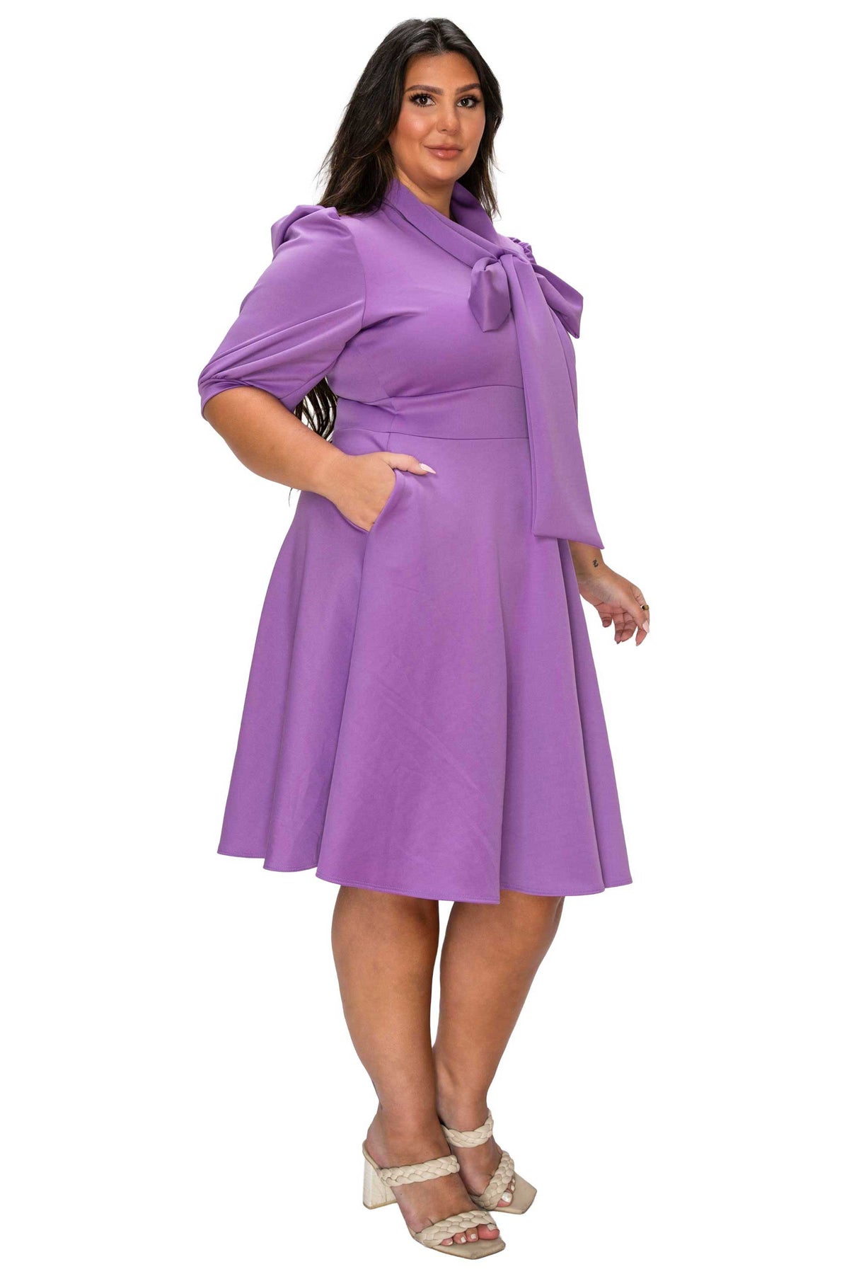 Woman wearing a purple dress with a belt on a white background
