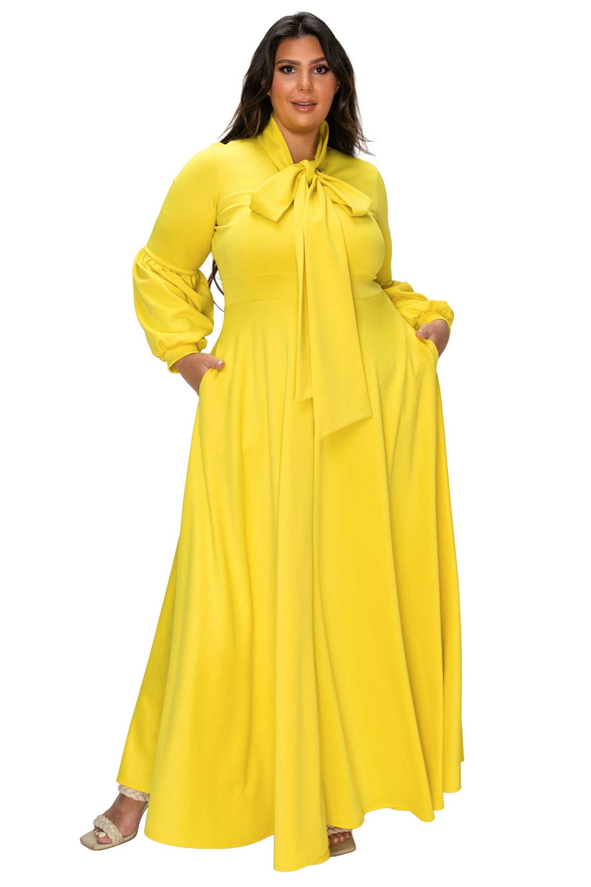 Woman wearing a yellow dress with a large bow on a white background