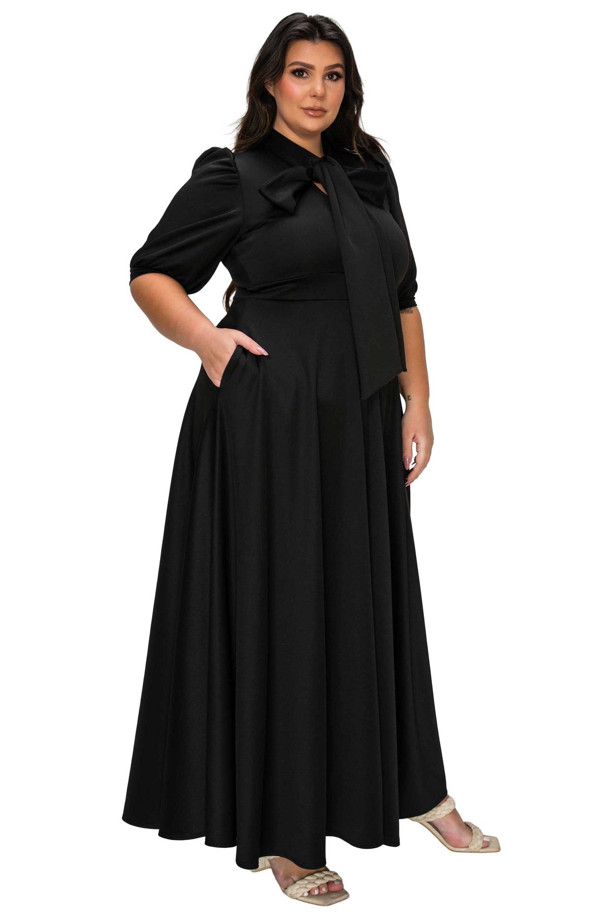 Woman wearing a black dress with a bow detail on a white background