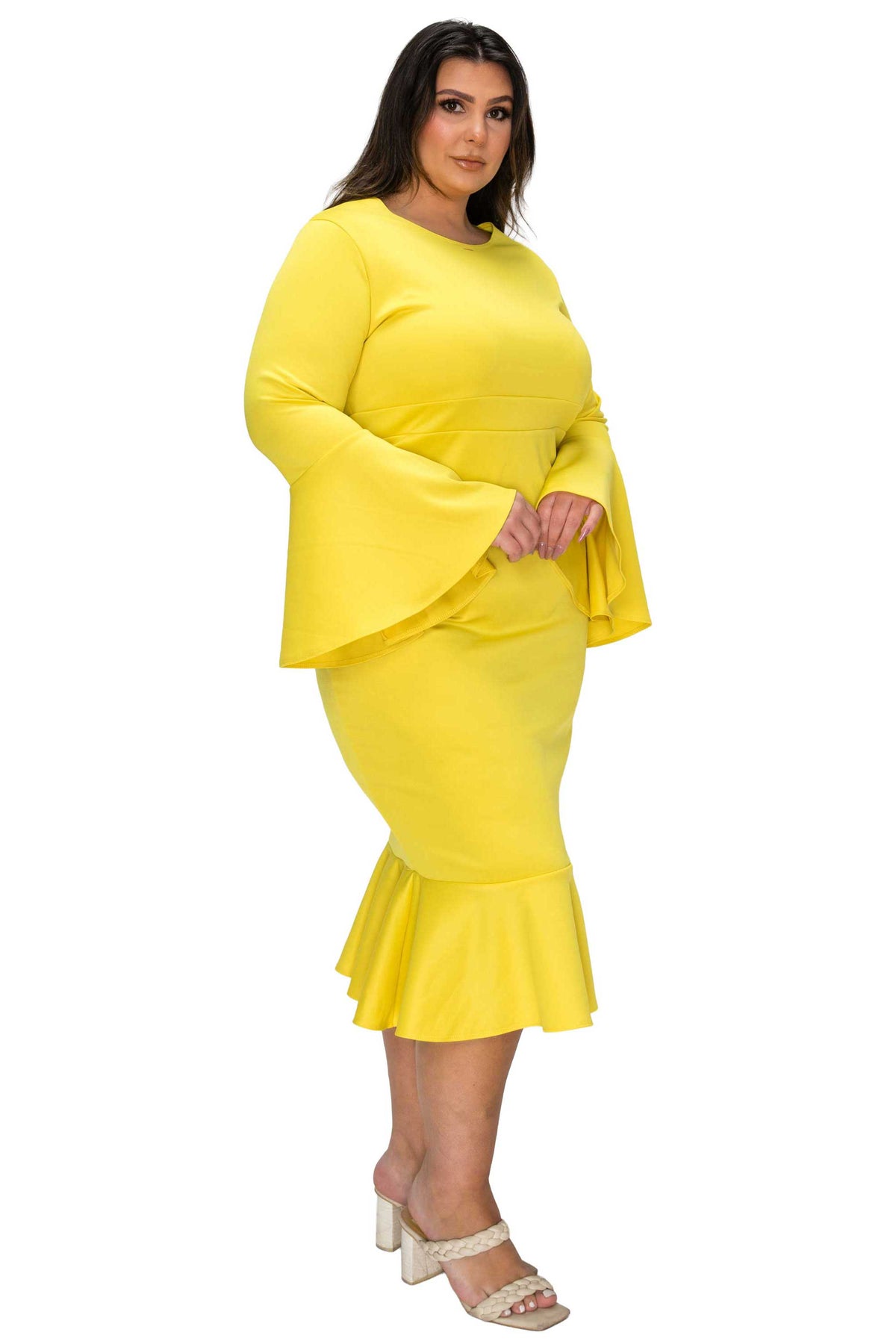 Woman wearing a bright yellow dress with bell sleeves on a white background