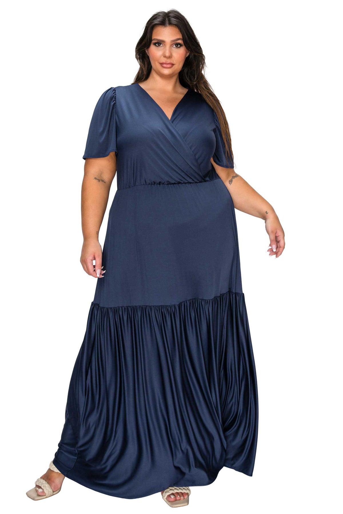 Woman wearing a navy blue dress with a layered skirt on a white background