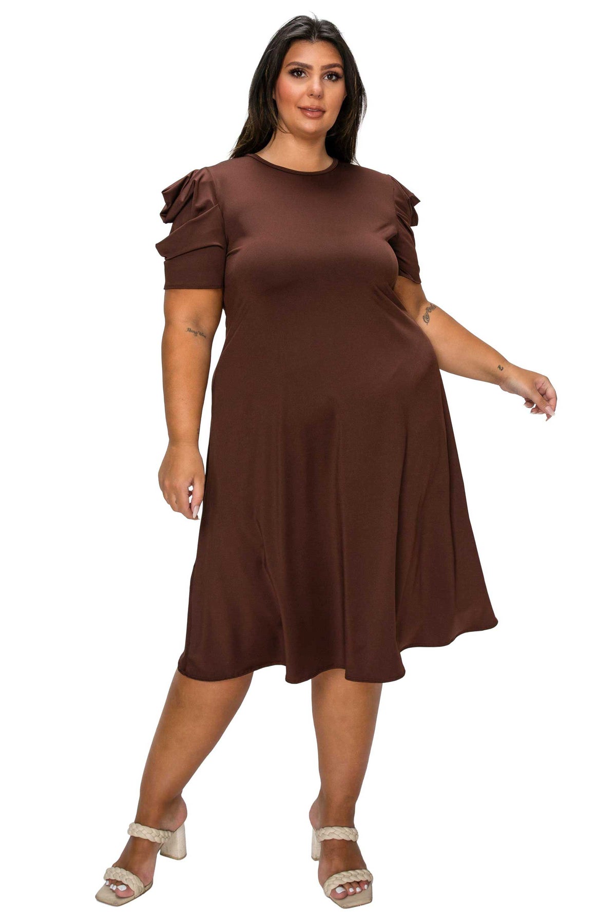 A woman modeling a brown short-sleeve midi dress with ruffled sleeves and a flared skirt, paired with beige heeled sandals, against a plain white background.