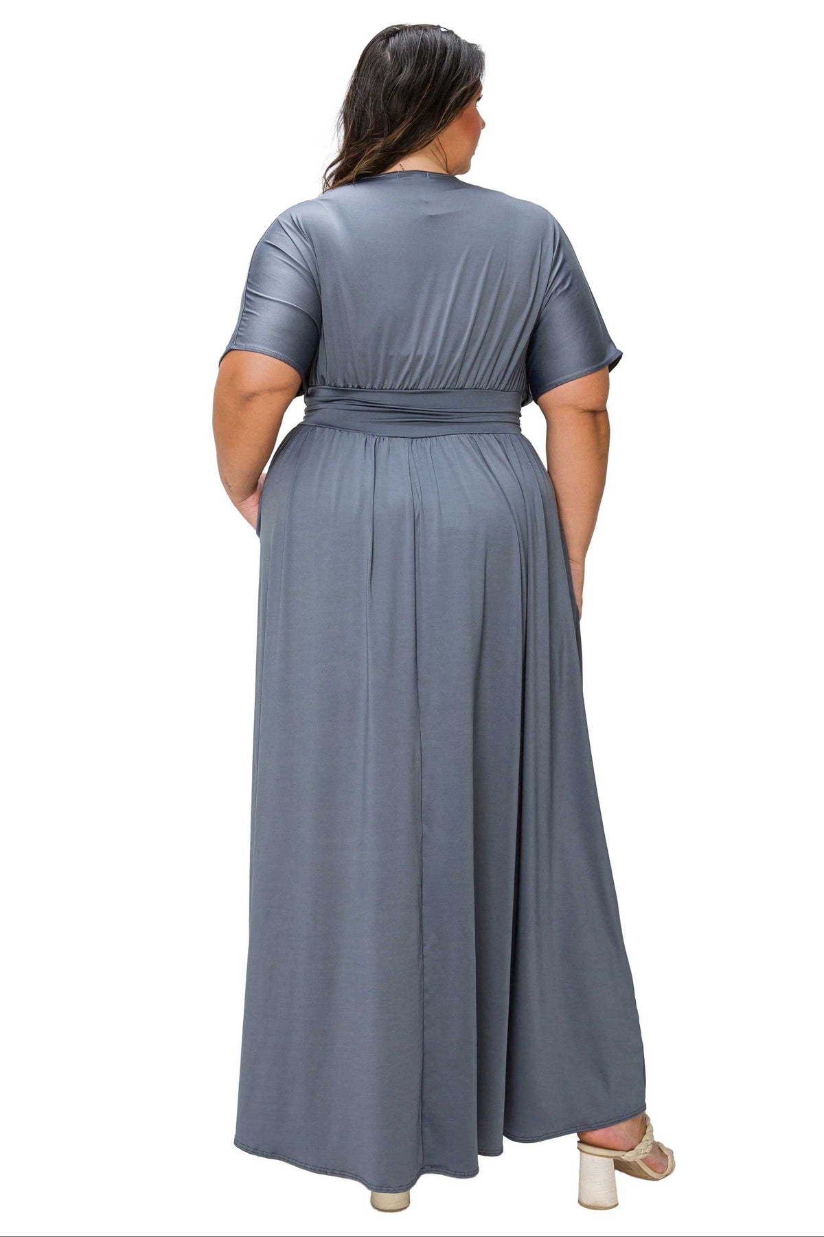 A woman shown from the back wearing a slate blue-gray short-sleeve maxi dress with a matching waist tie, set against a plain white background.