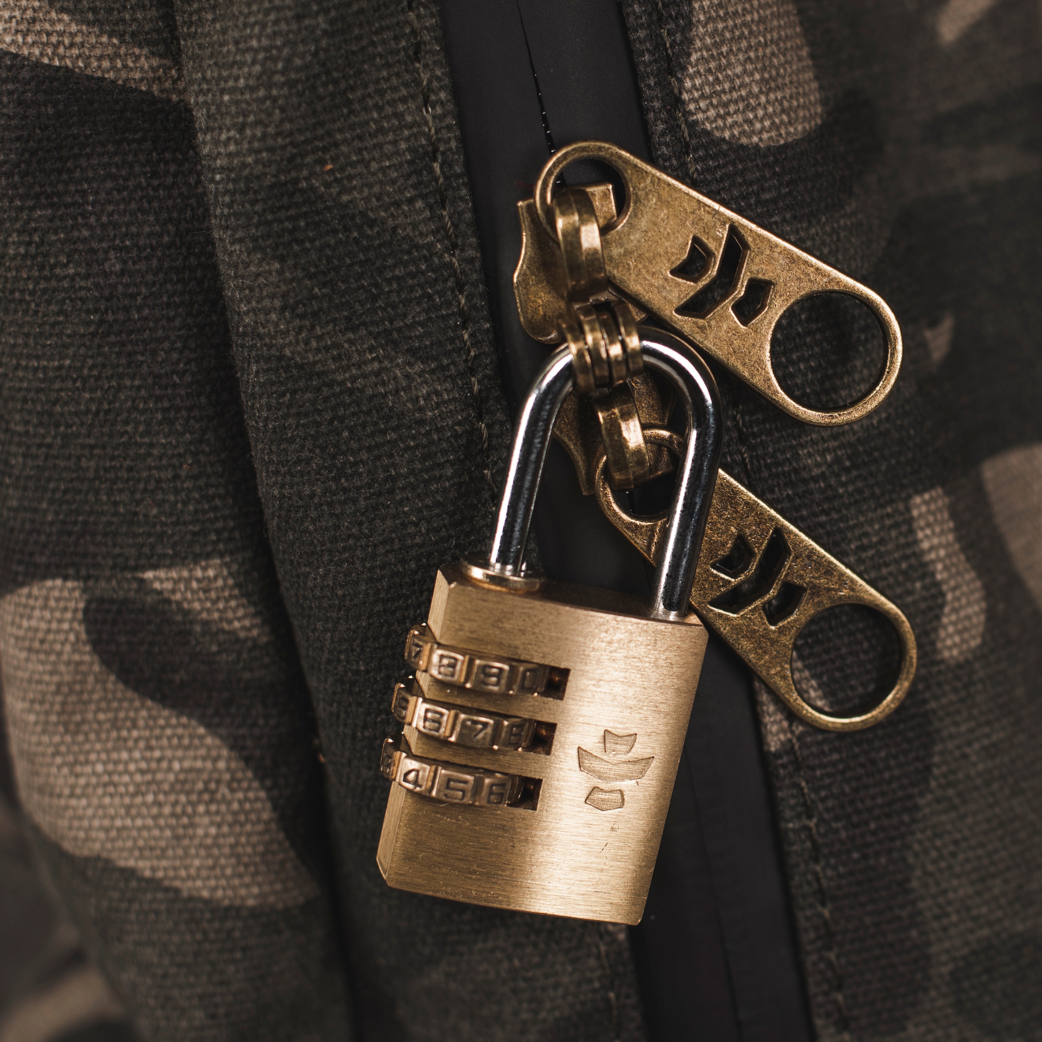 Bronze padlock with keychain on a camouflage background