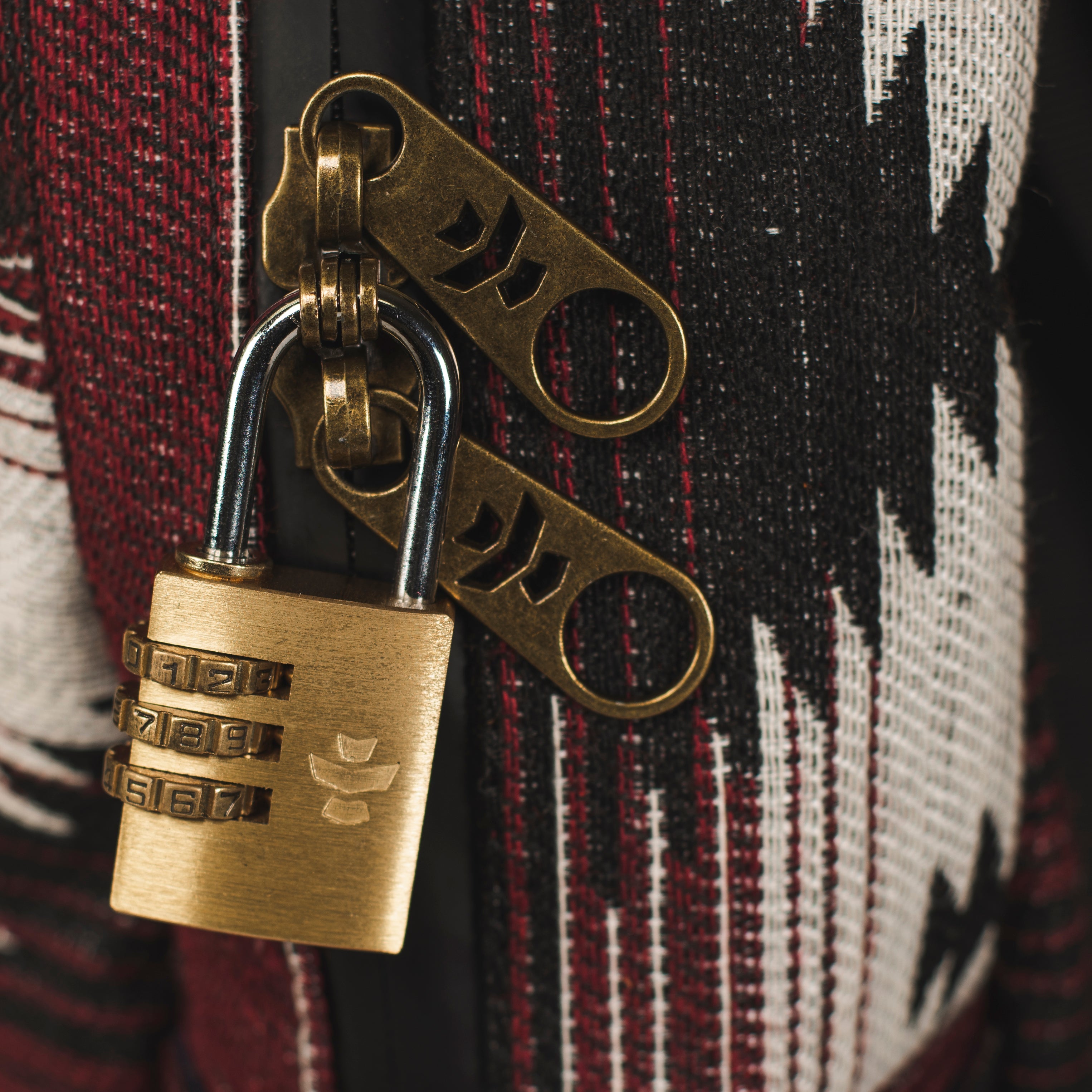 Brass padlock with two keys on a patterned fabric background