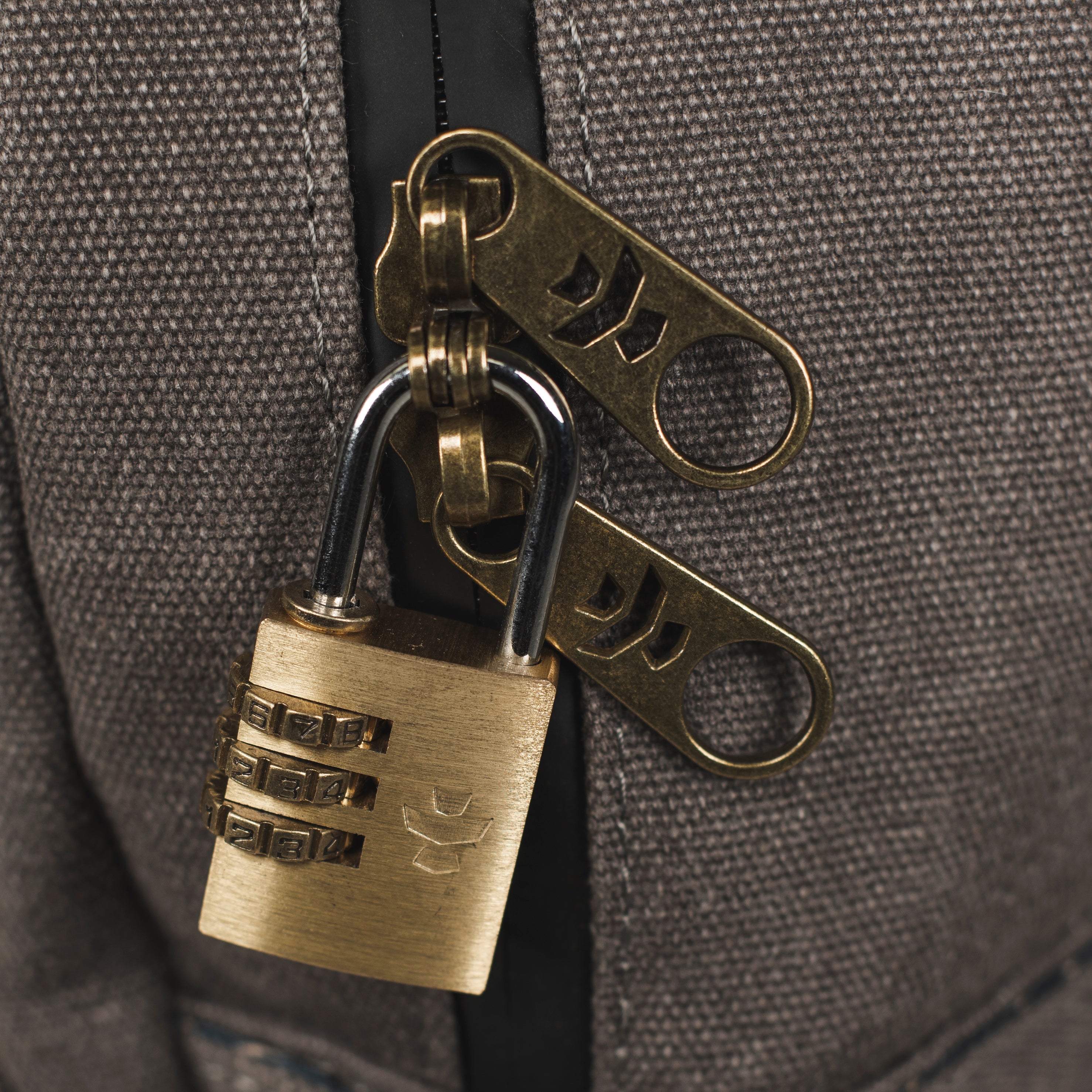 Brass padlock and keychain on a textured surface