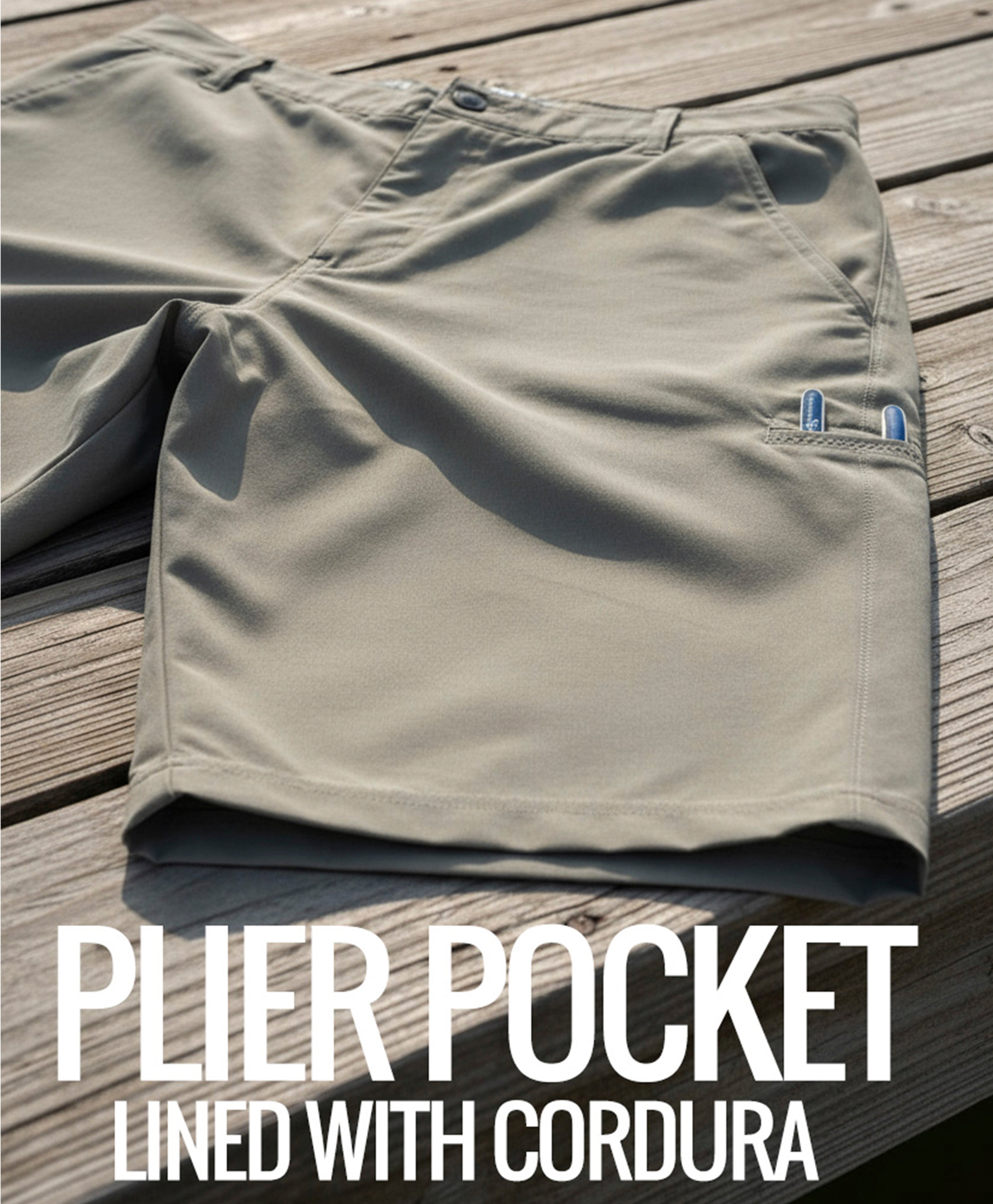 Khaki shorts with plier pocket on a wooden surface, featuring text 'PLIER POCKET LINED WITH CORDURA'.