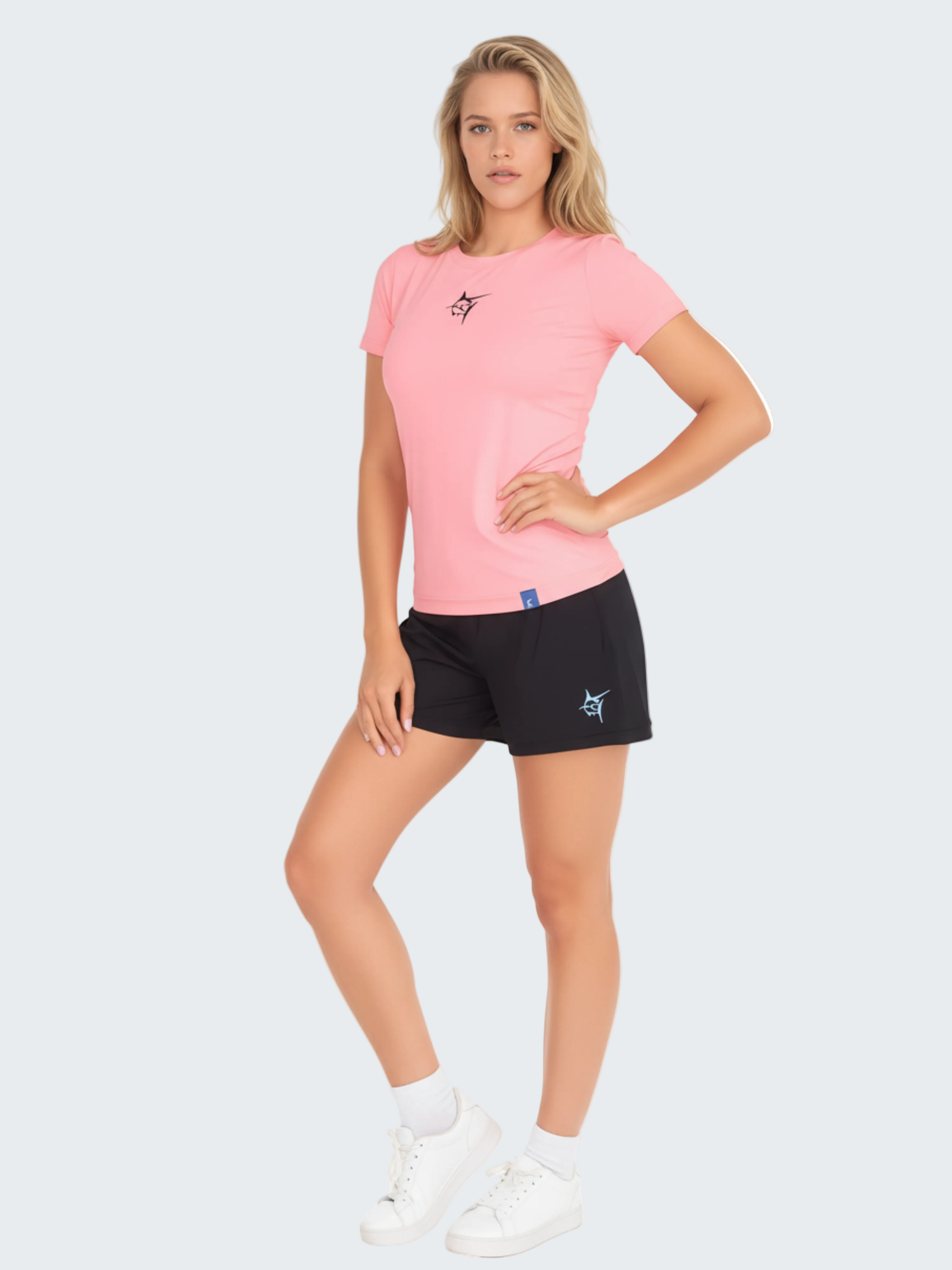 Woman wearing a pink t-shirt and black shorts on a white background