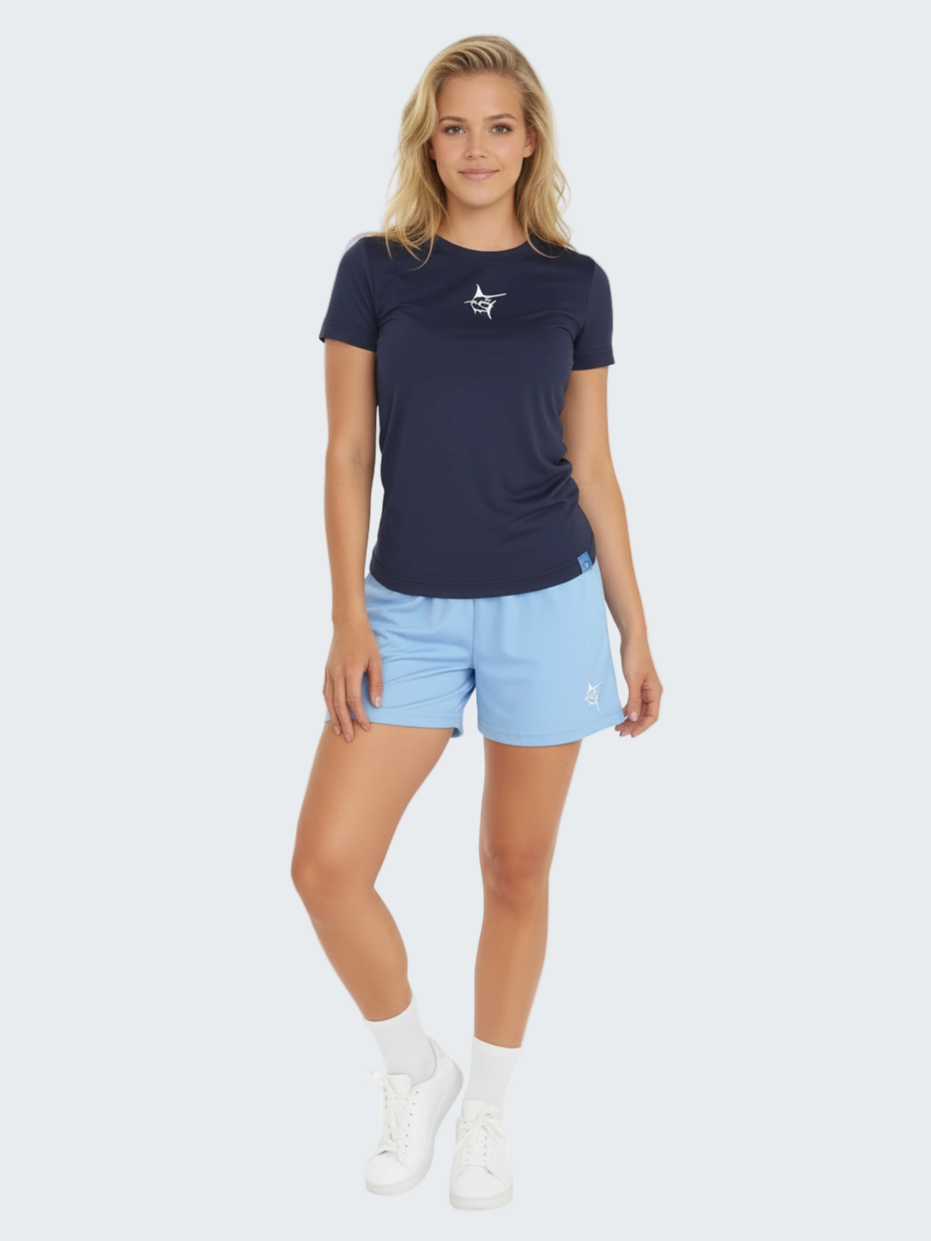 Woman wearing a navy t-shirt and light blue shorts on a white background