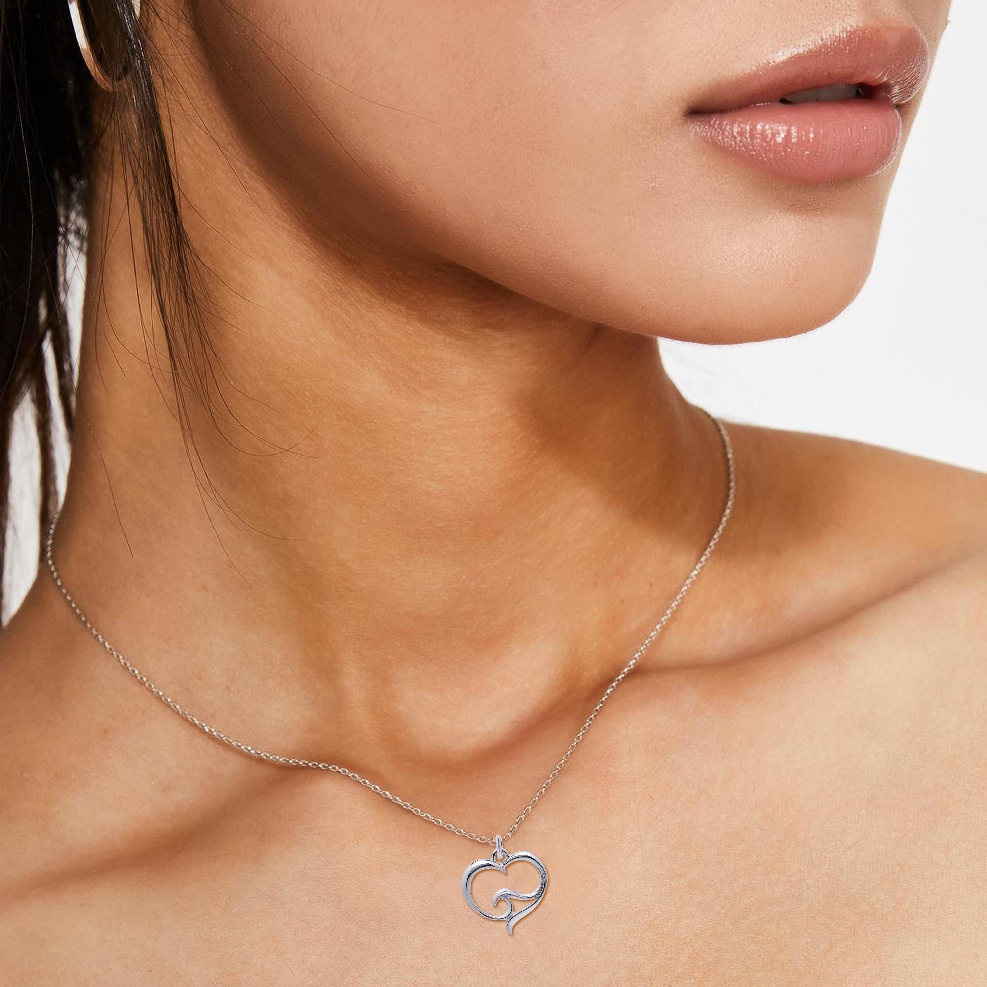 Silver necklace with a heart-shaped pendant worn by a model