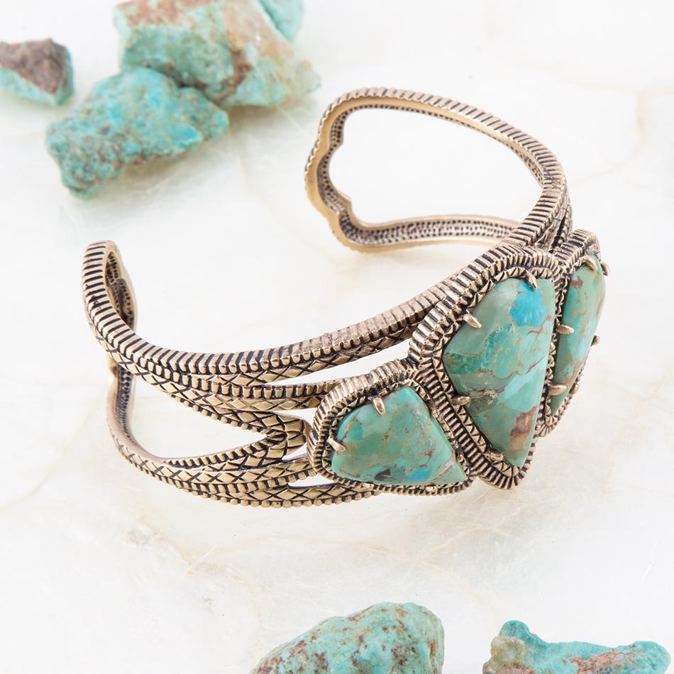 Bronze bracelet with turquoise stones on a light background