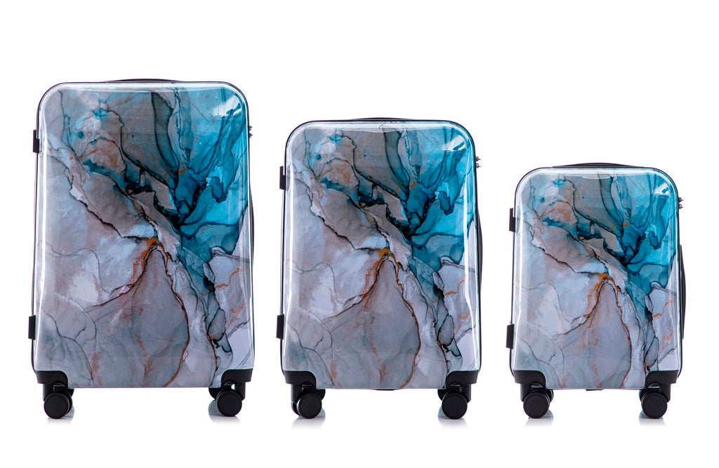 Set of three marble-patterned suitcases on a white background