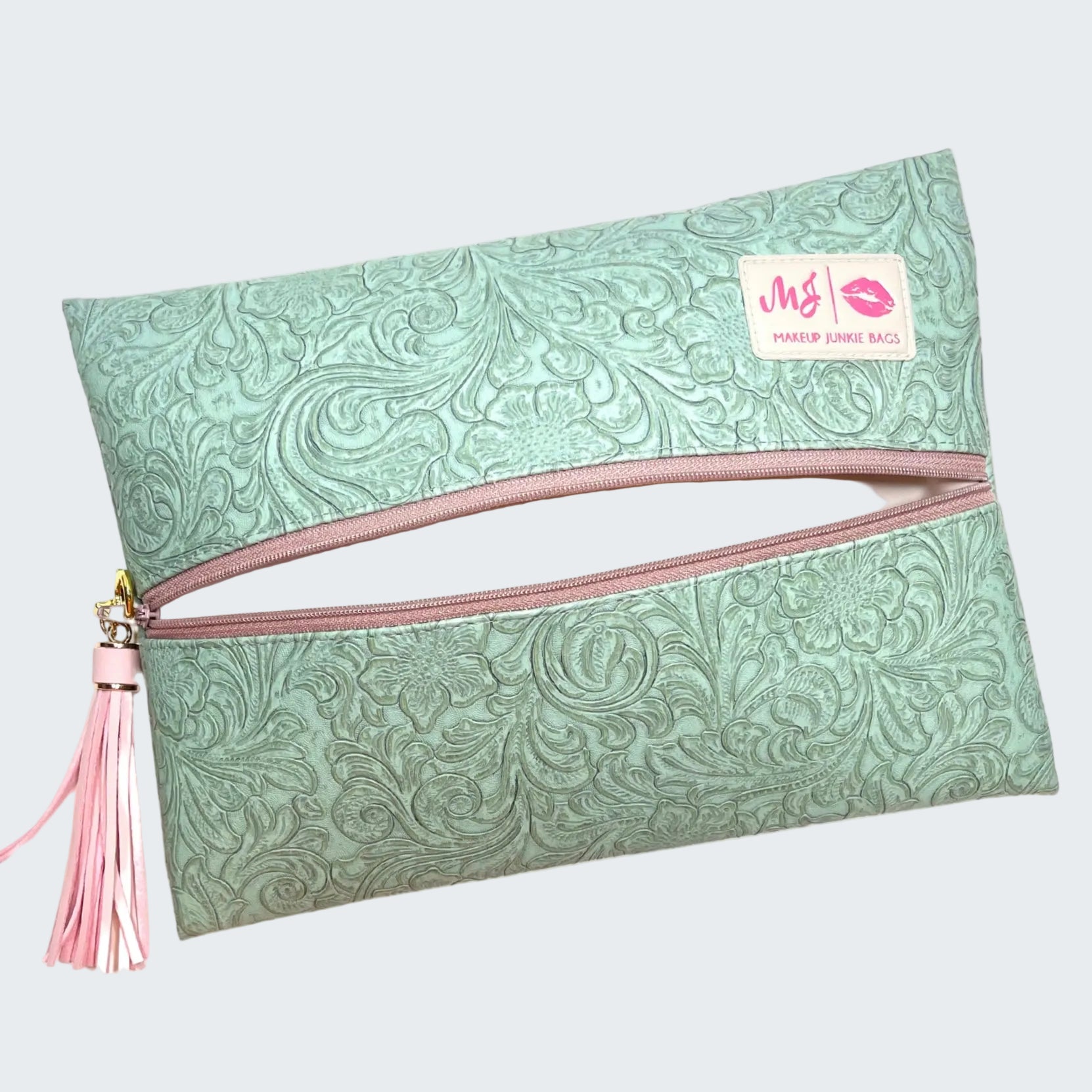 Green patterned pouch with pink zipper and tassel on a white background