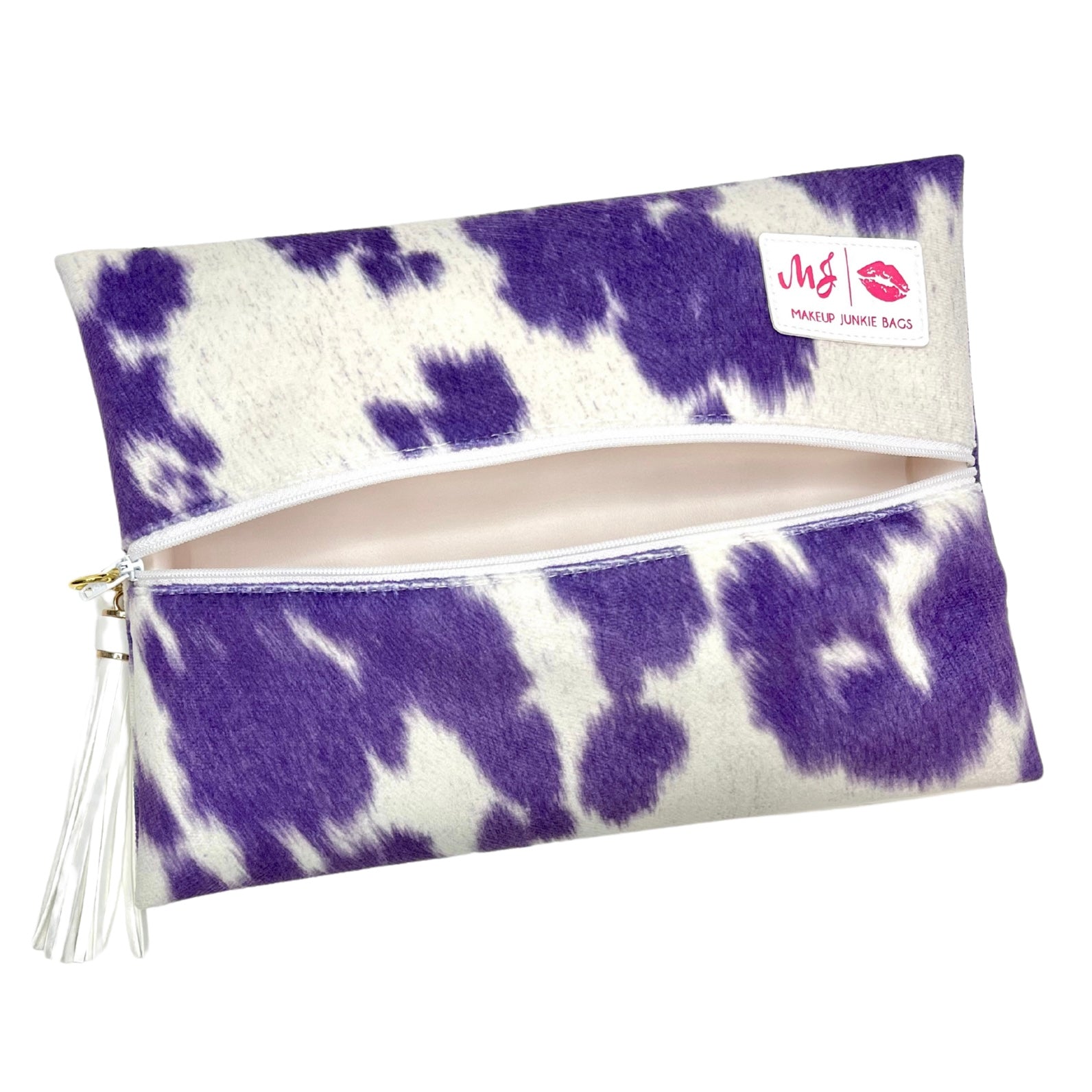 Purple and white cow print makeup bag with a visible brand label on a white background